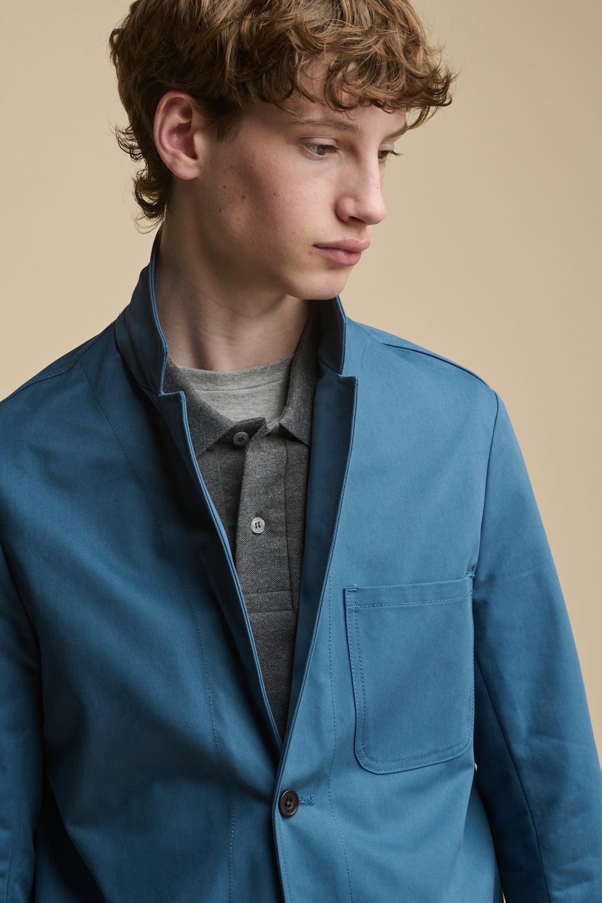 Portrait of male looking down wearing Men's James Single Breasted Blazer in RAF Blue with the collar up