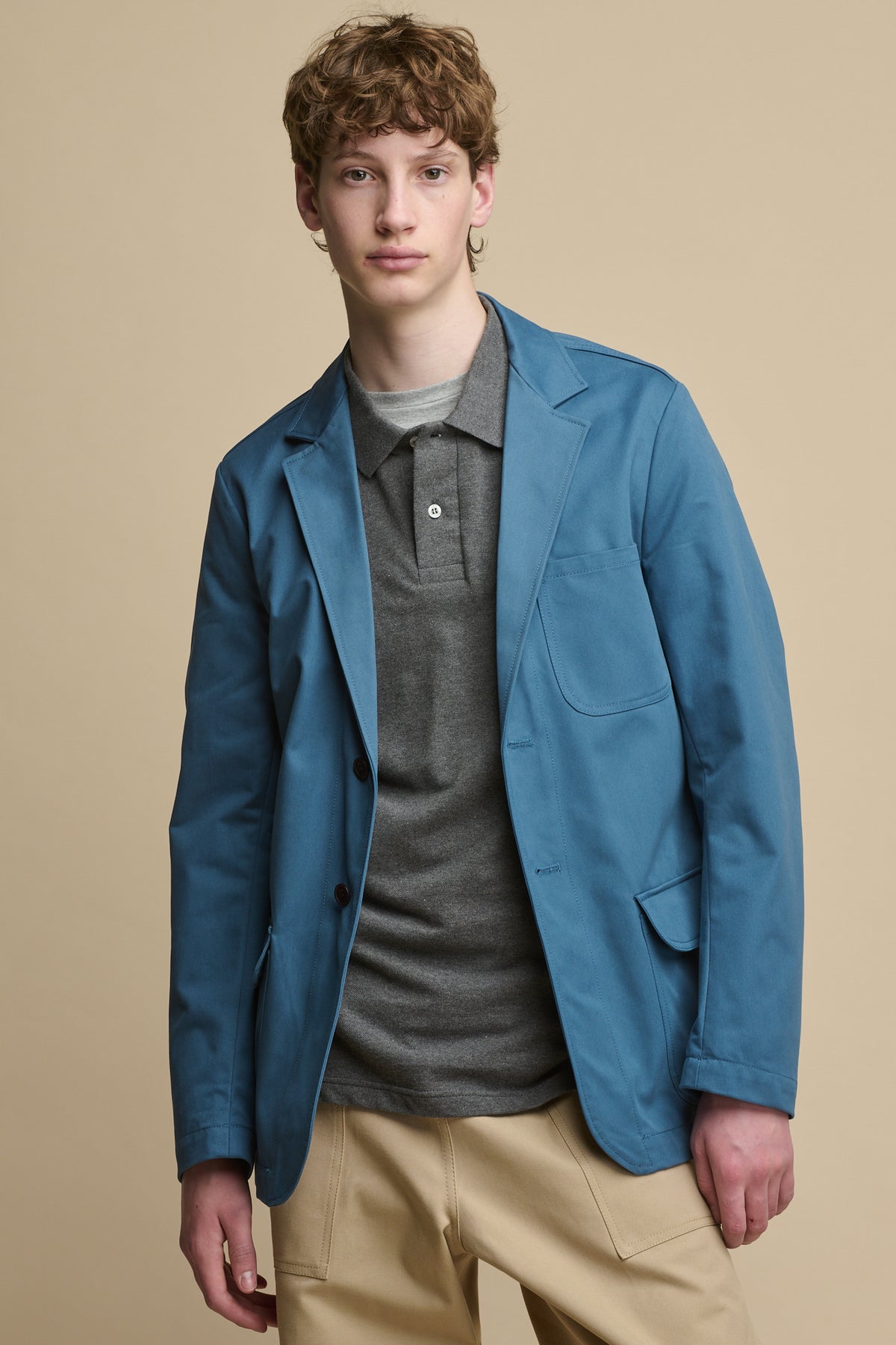 Thigh up image of male wearing Men's James Single Breasted Blazer in RAF Blue over short sleeve t shirt and polo shirt in grey