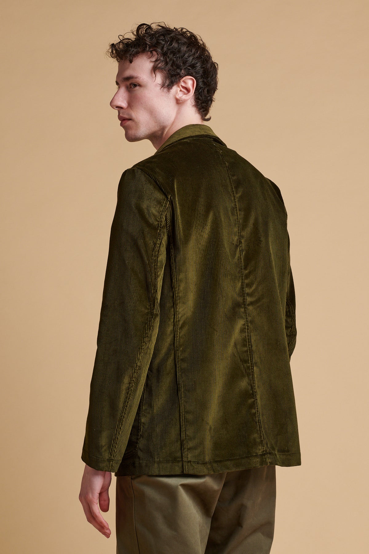 The back of male wearing James single breasted corduroy blazer in olive.