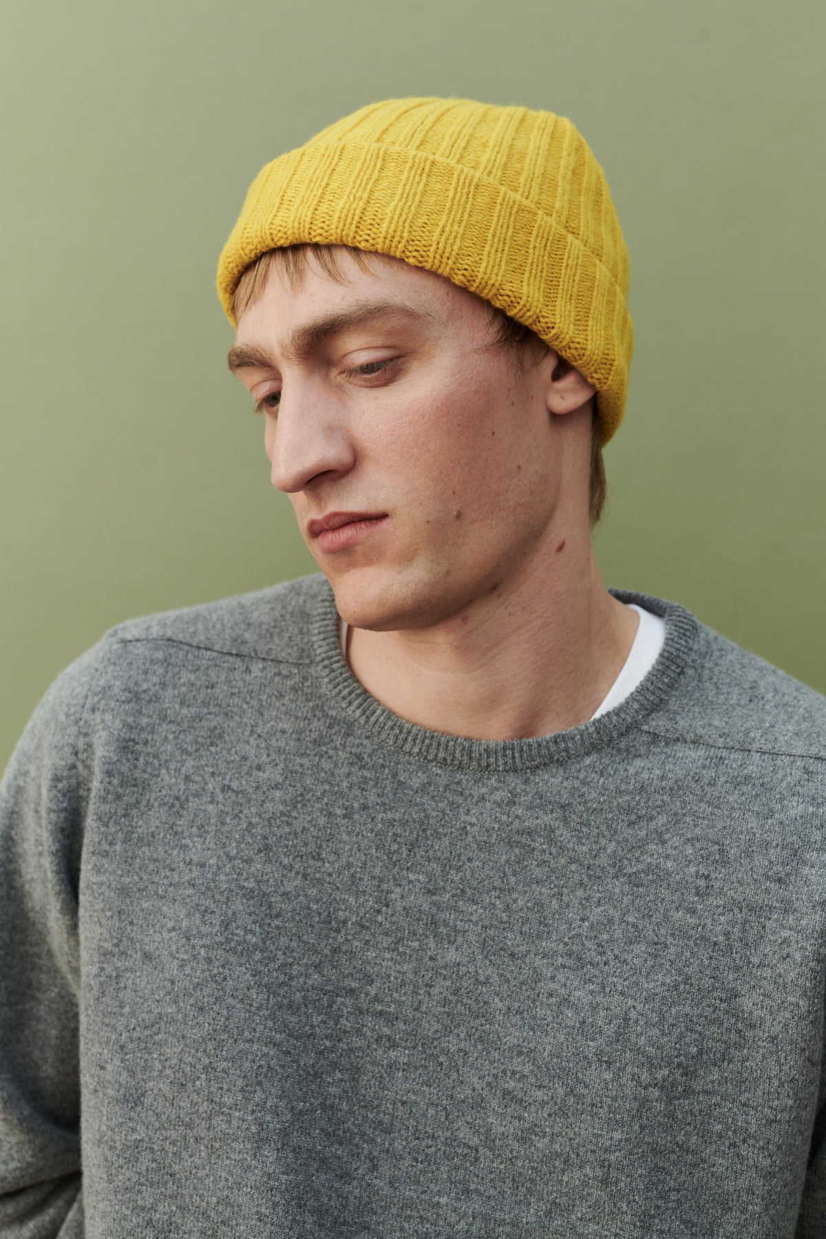 
            Male wearing unisex lambswool beanie hat in mustard