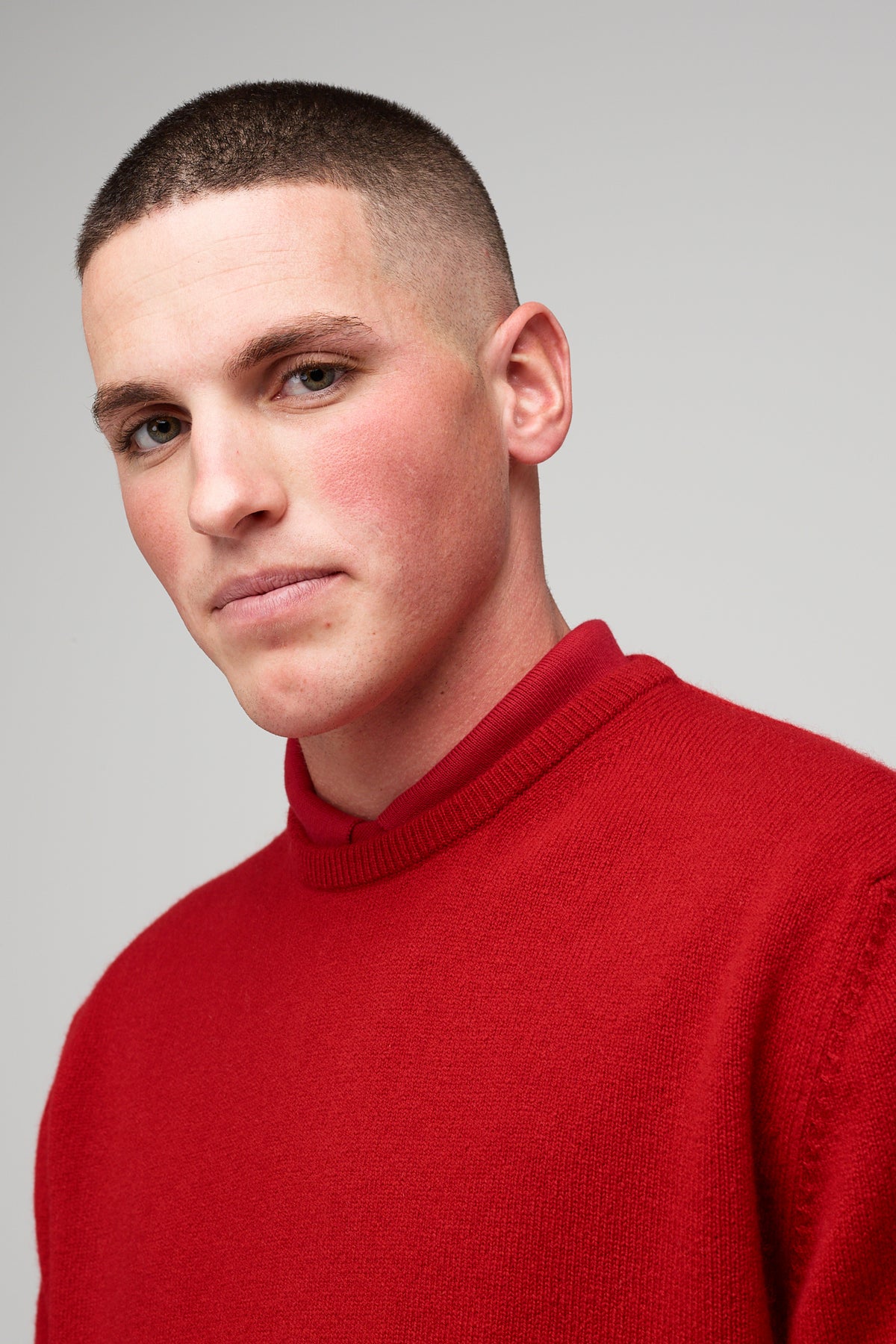 
            Brunette, white male wearing men&#39;s Lambswool Crew Neck in red styled over red short sleeve polo head shot