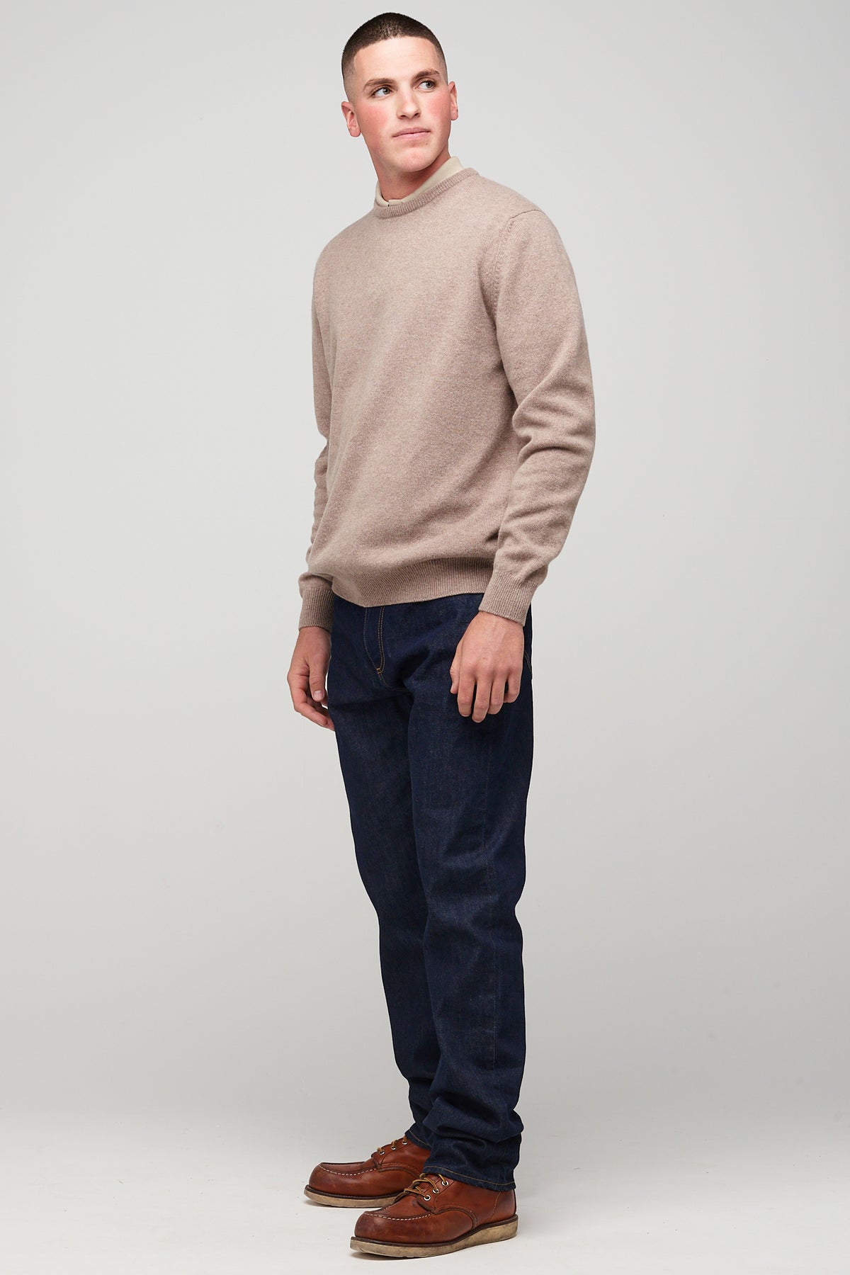 brunette, white male in taupe lambswool crew neck styled with denim jeans