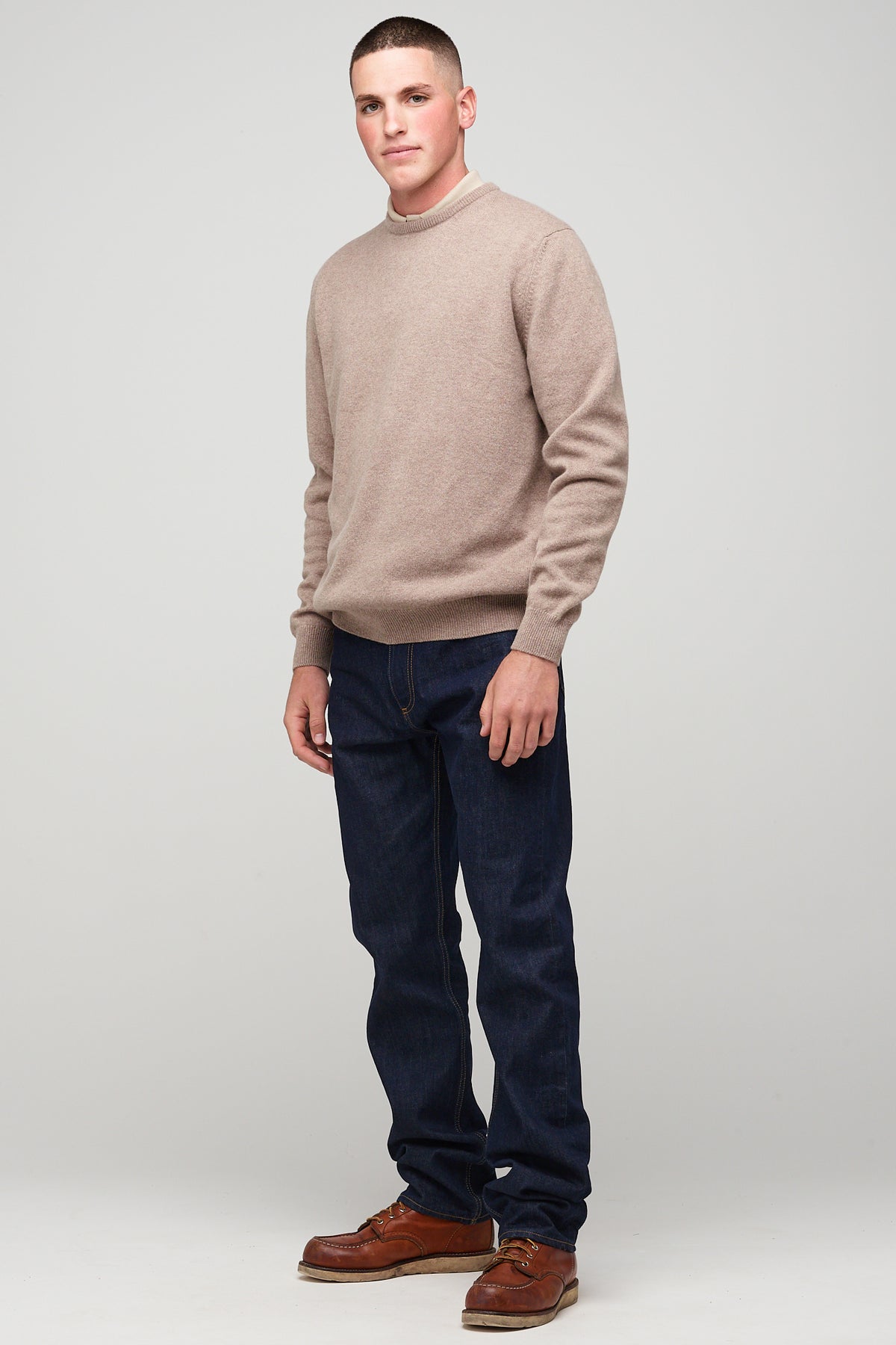 brunette, white male in taupe lambswool crew neck, styled with denim jeans