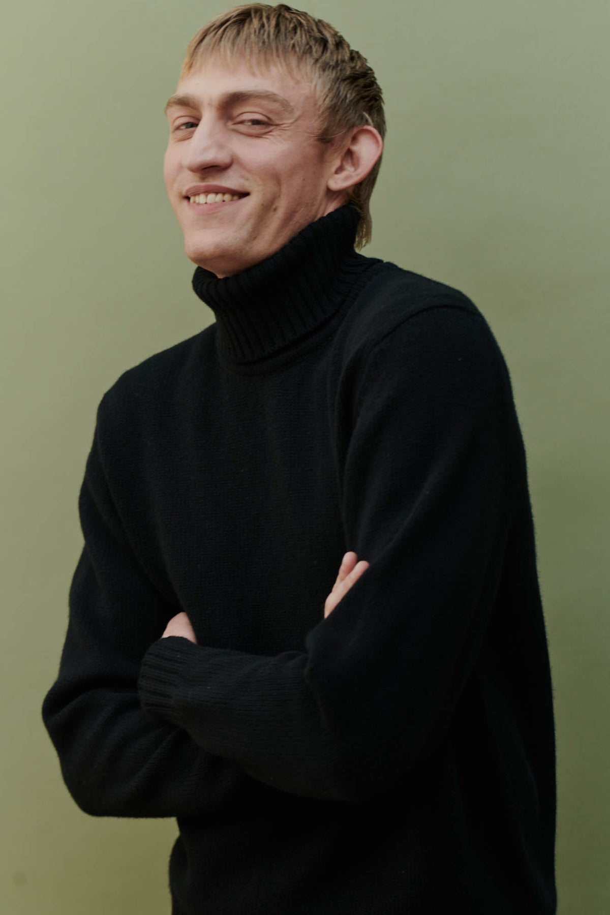 
            Smiley, white male wearing lambswool roll neck in black