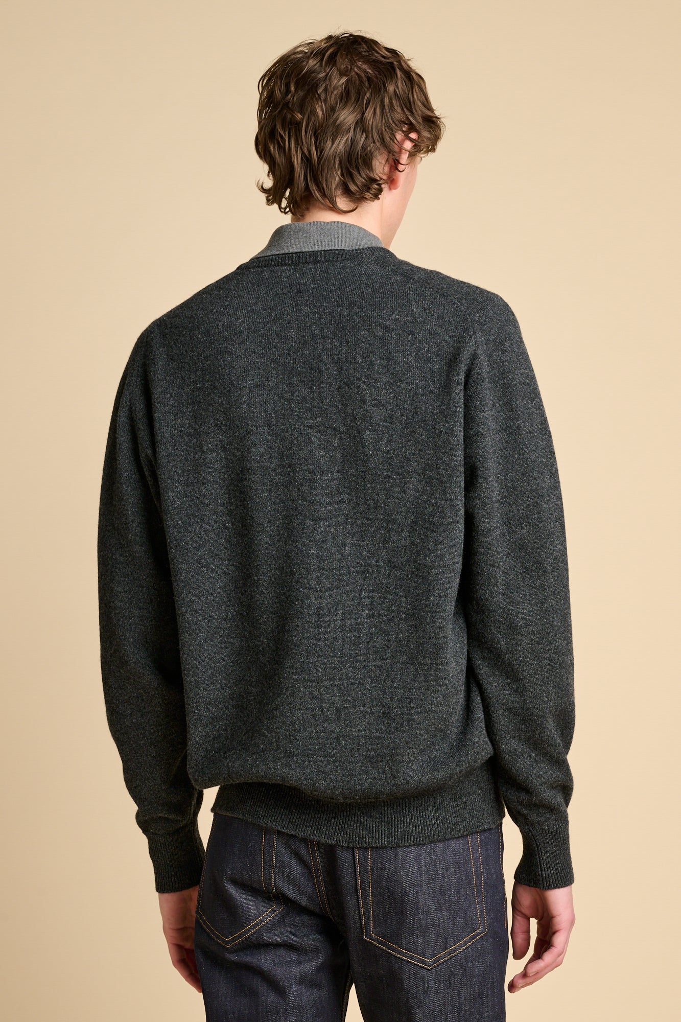 Bag of male wearing a charcoal marl lambswool v neck jumper