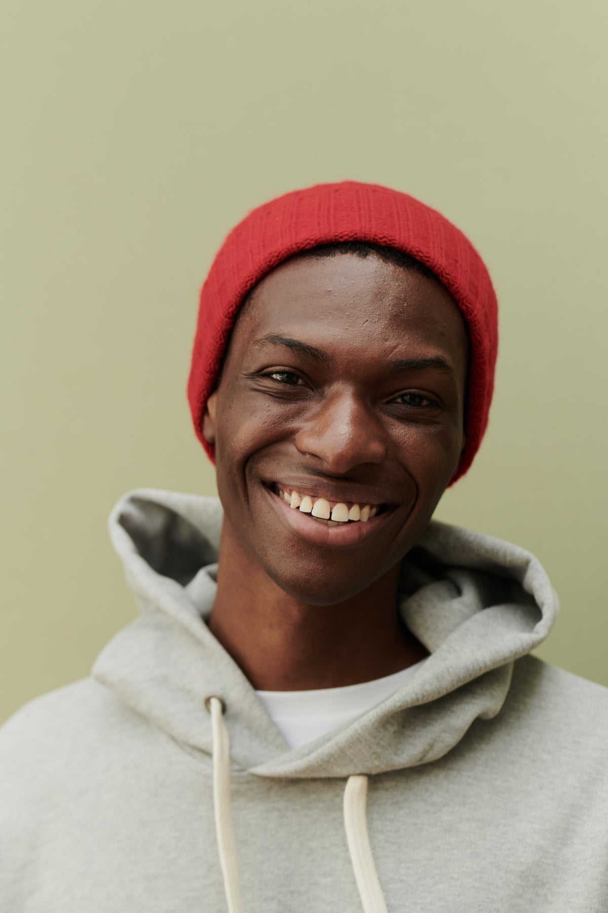 
            Male wearing unisex lambswool beanie hat in red