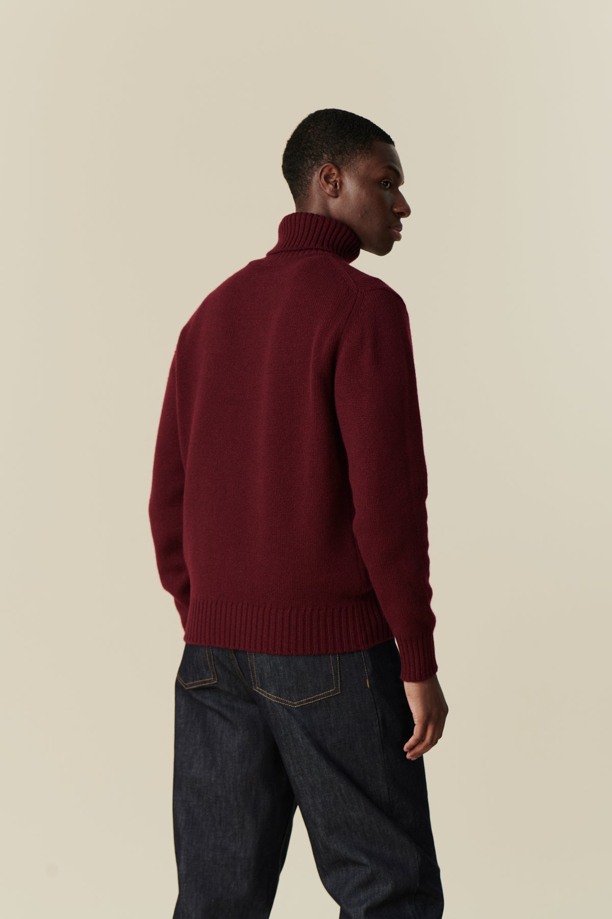 Back of male wearing lambswool roll neck in burgundy