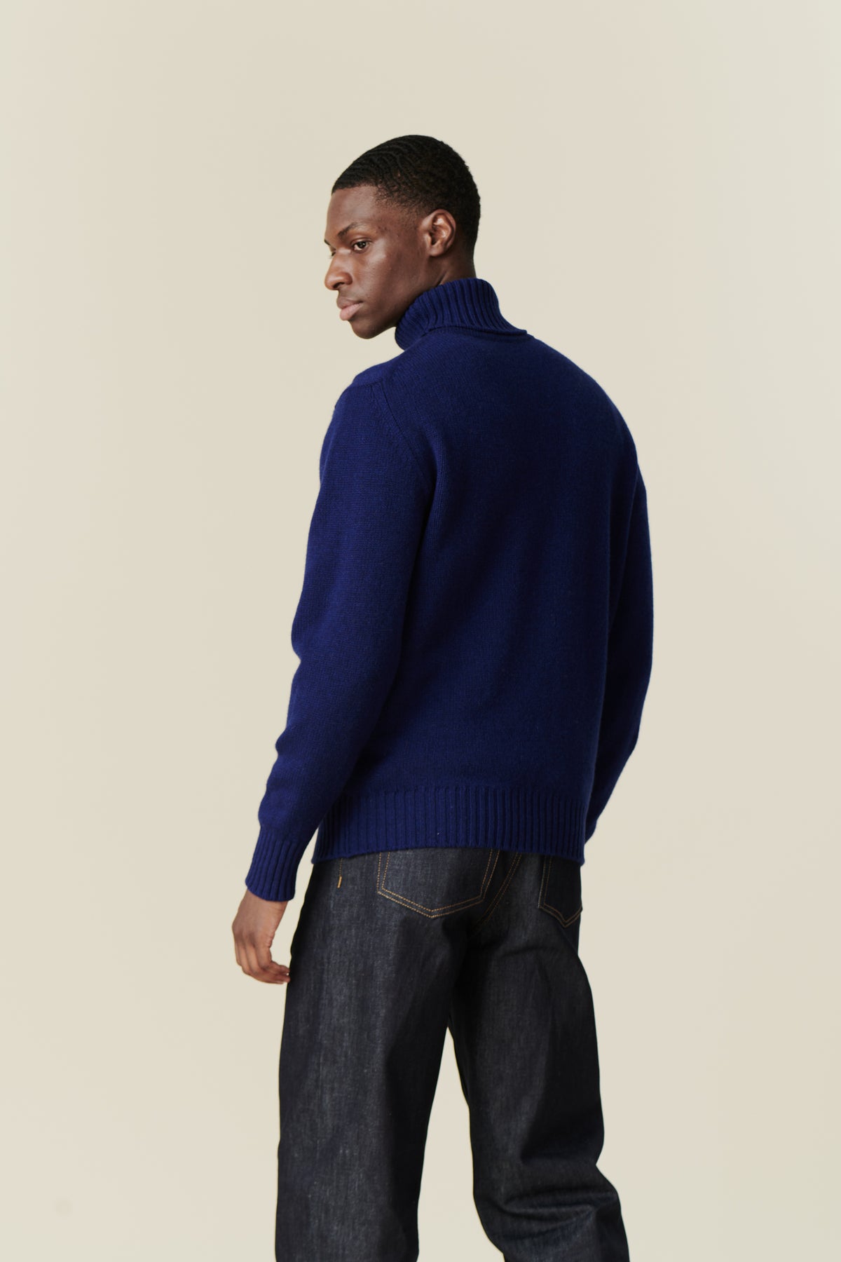 Back of black male wearing lambswool roll neck dark cobalt