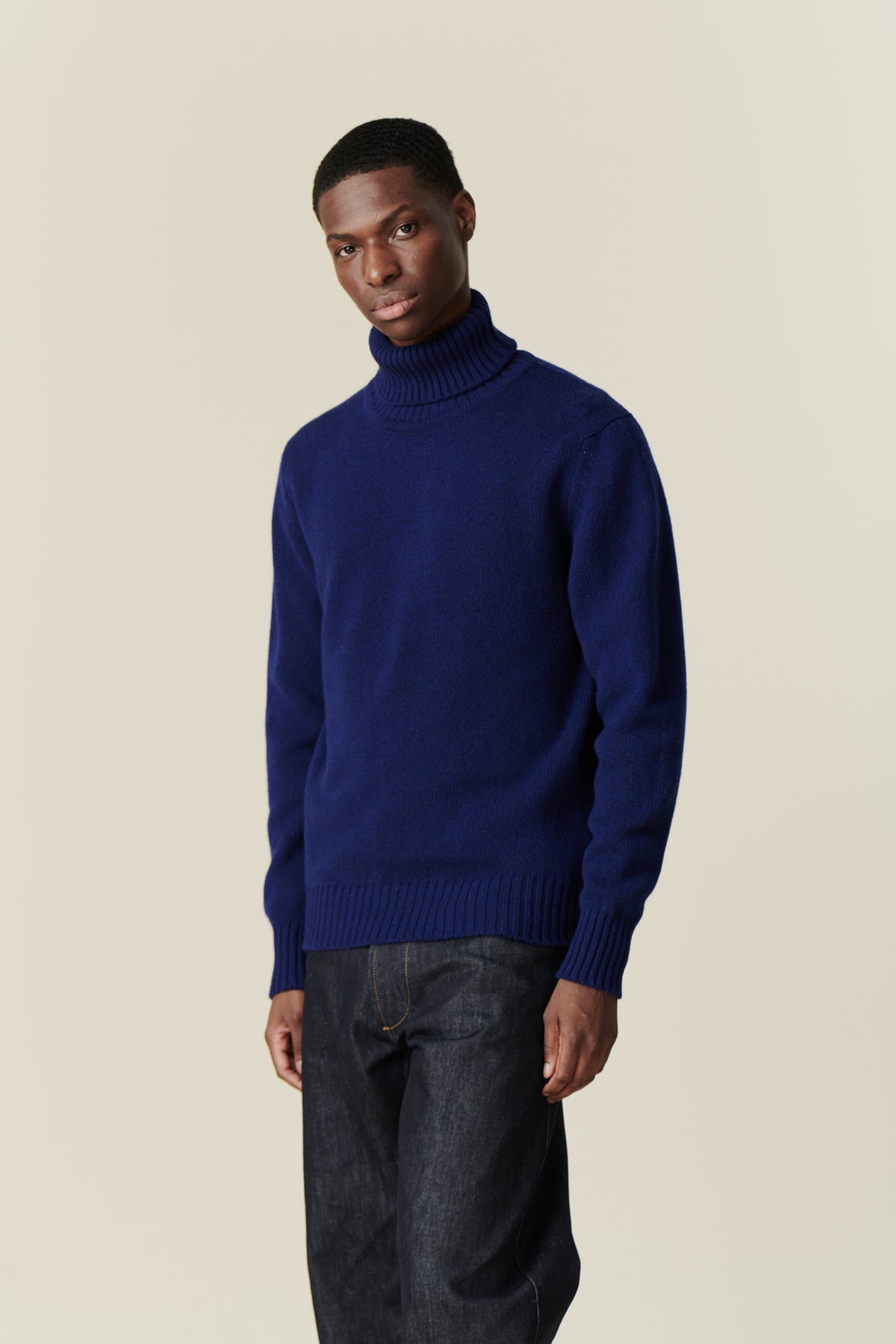 Black male wearing lambswool roll neck dark cobalt