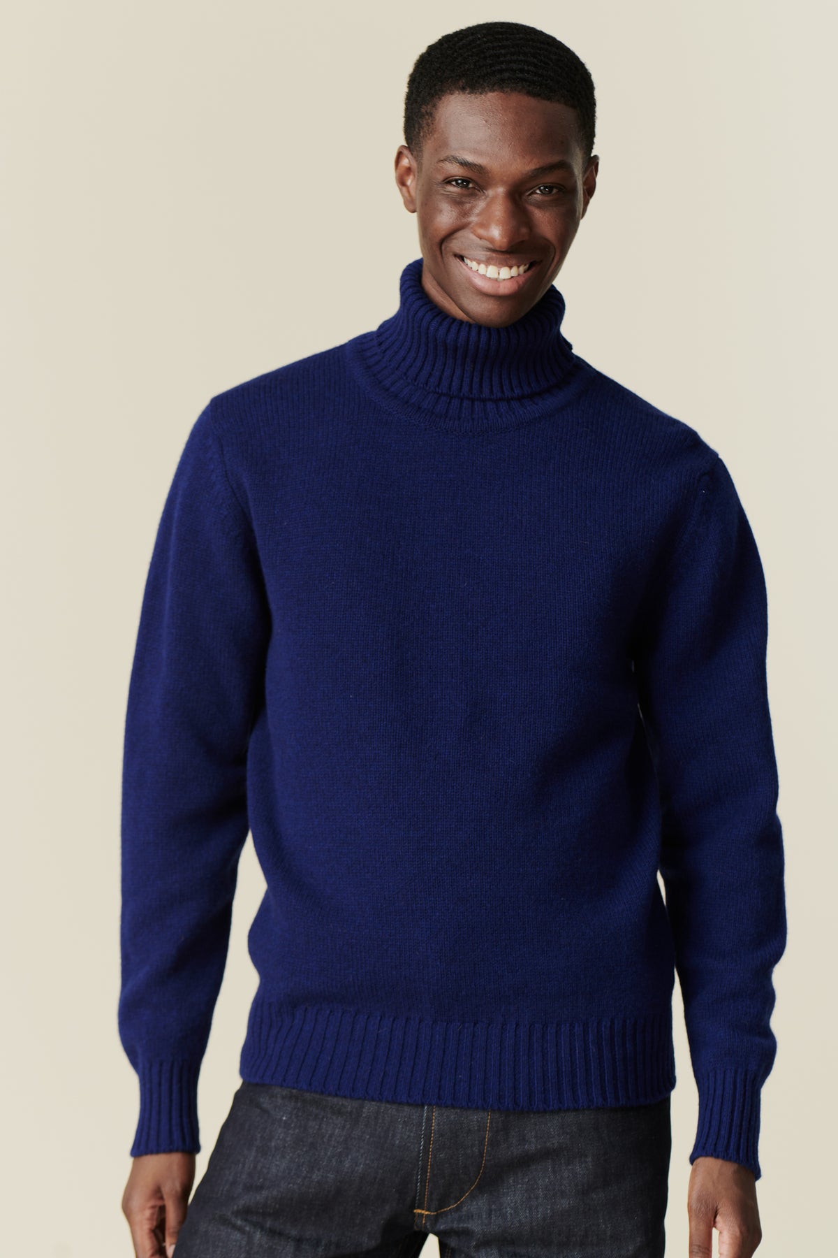 Smiley, black male wearing lambswool roll neck dark cobalt