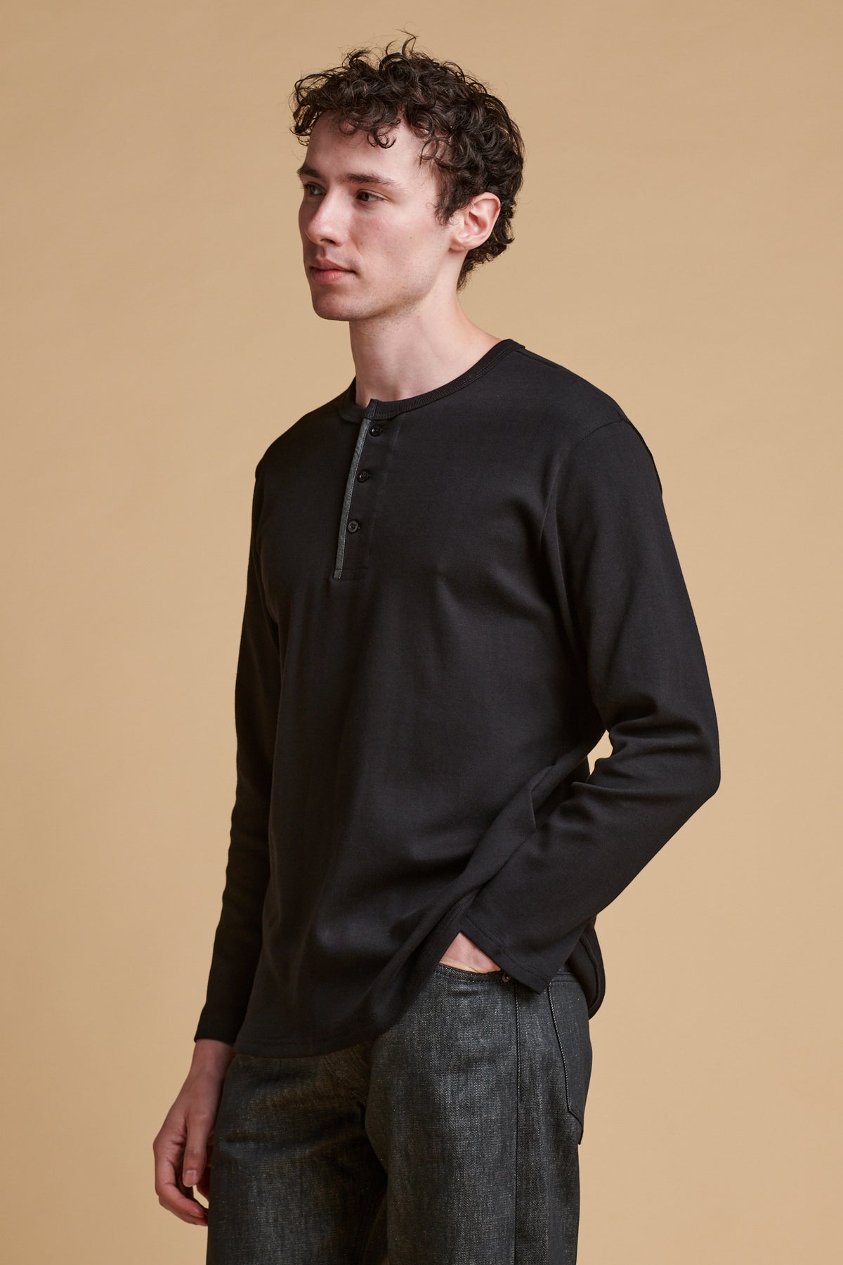Male wearing long sleeve Henley top in black
