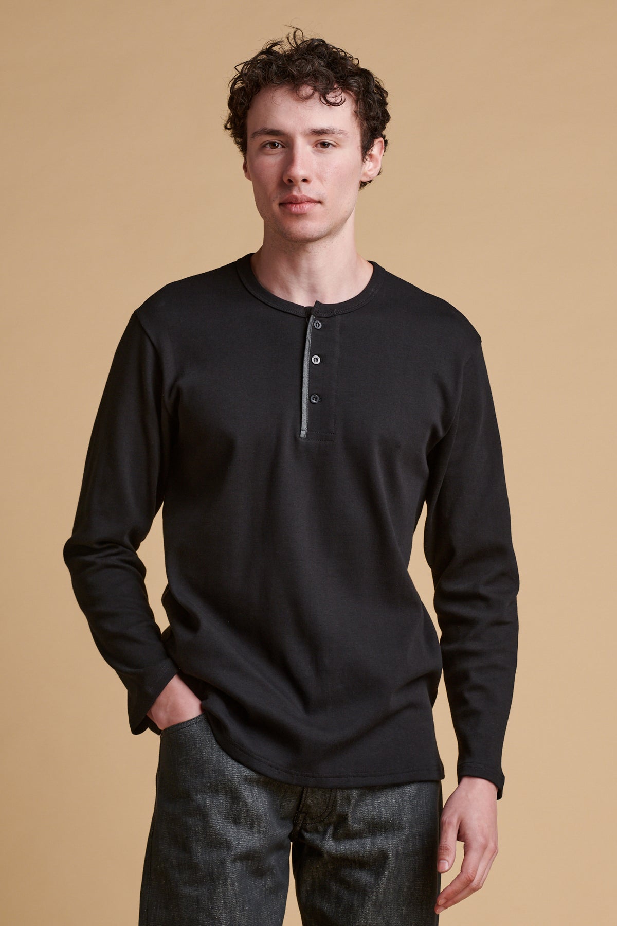 Male wearing long sleeve Henley top in black