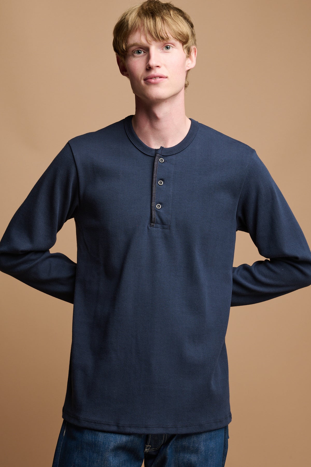 
            Thigh up of male wearing long 3 button sleeve blue henley top  