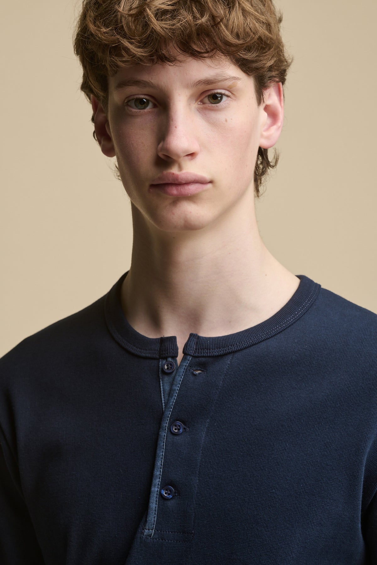 Portrait of male wearing long sleeve Henley top in navy
