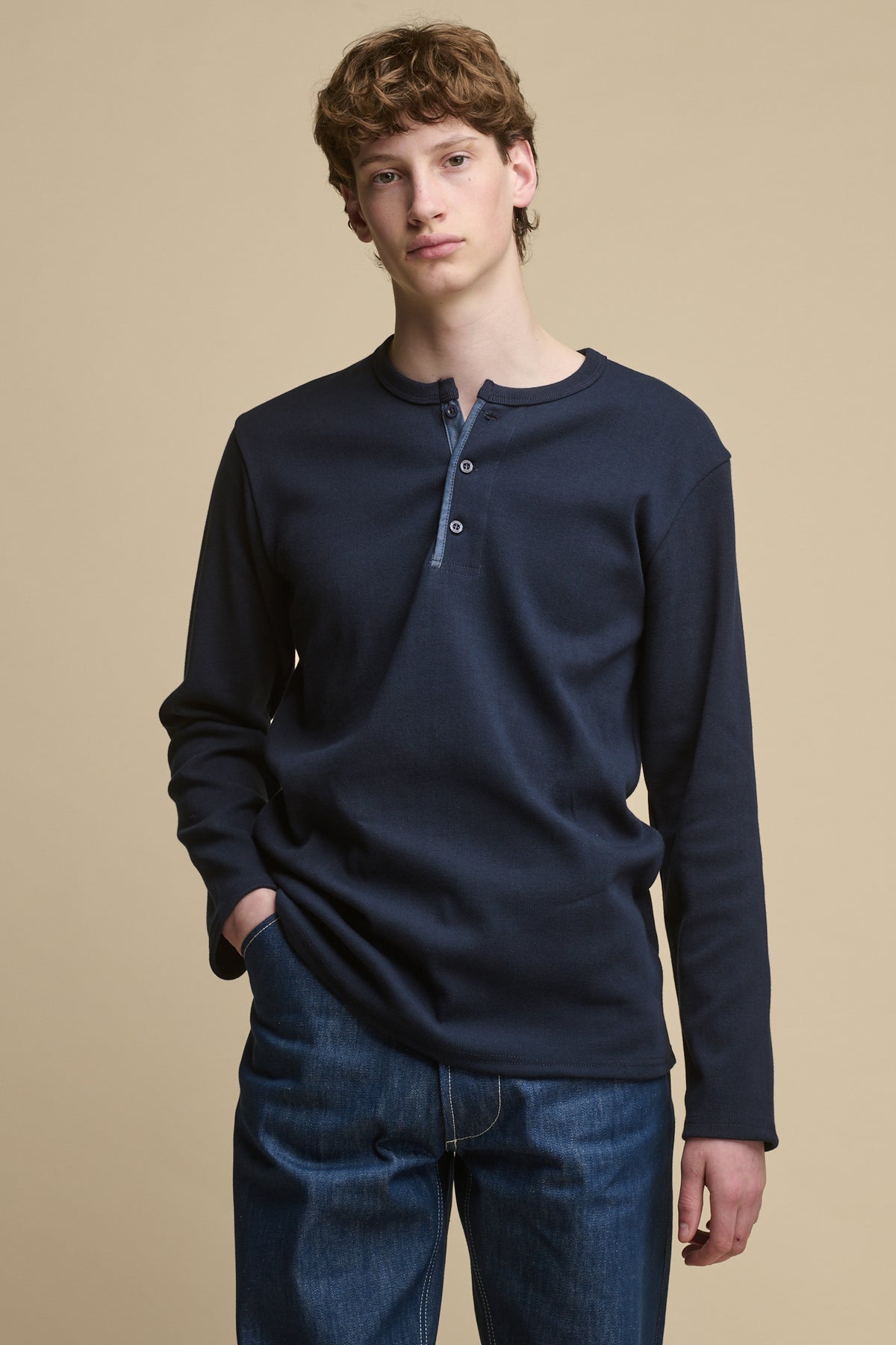 
            Thigh up image of male wearing Long Sleeve Henley top in Navy paired with men&#39;s blue jeans