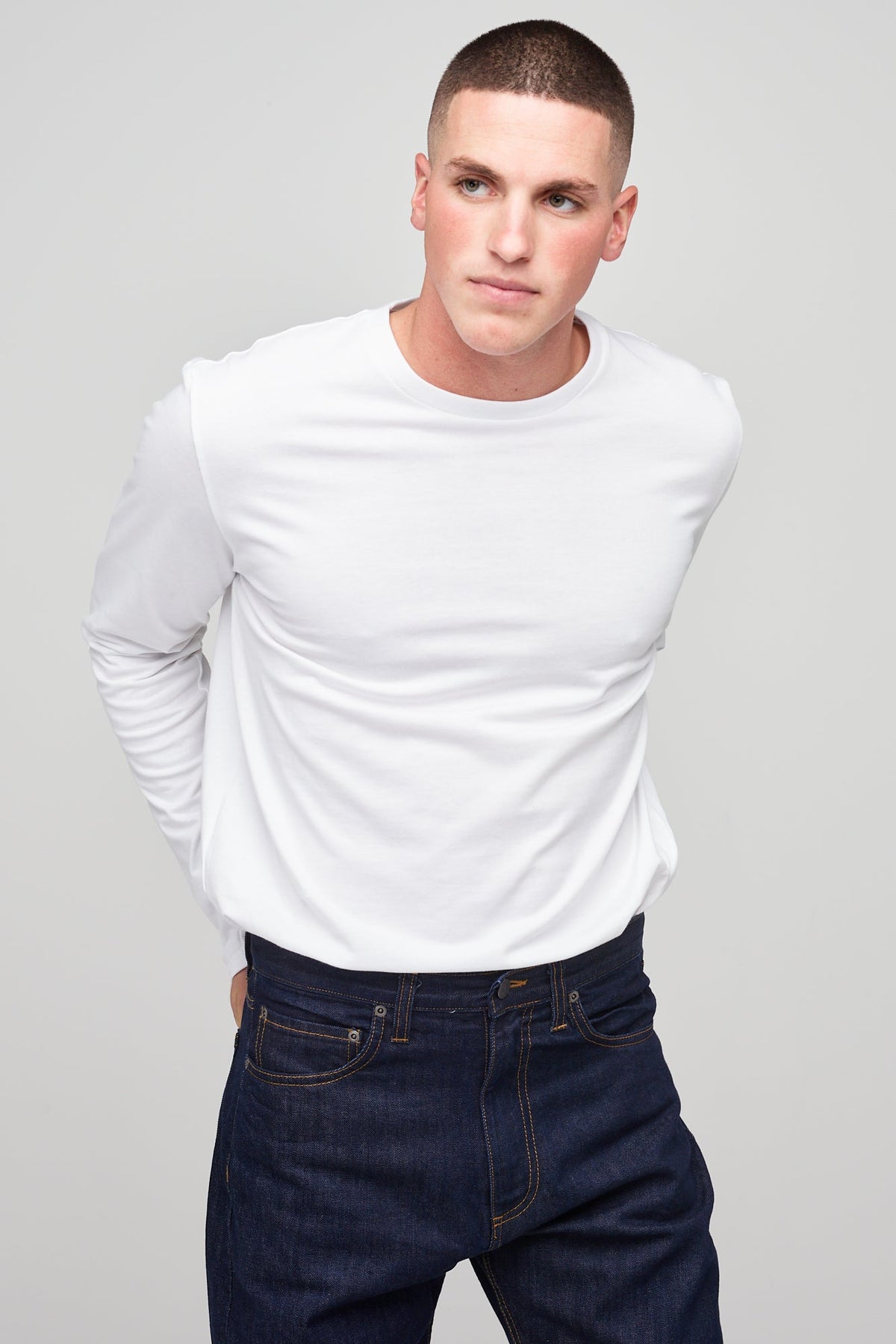 
            Brunet, white male wearing long sleeve t-shirt white tucked into with denim jeans 
