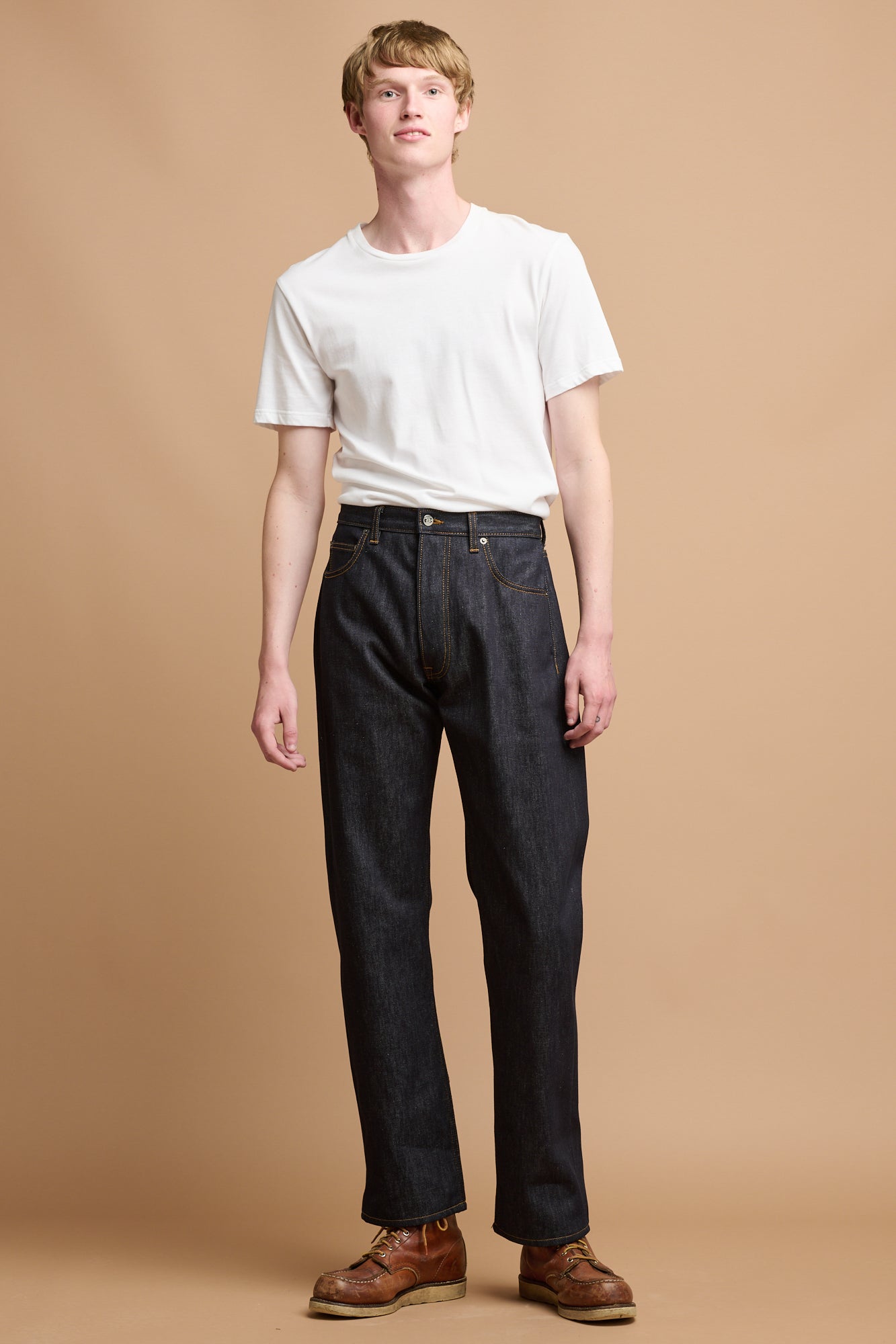 Male wearing white t shirt and selvedge denim jeans.