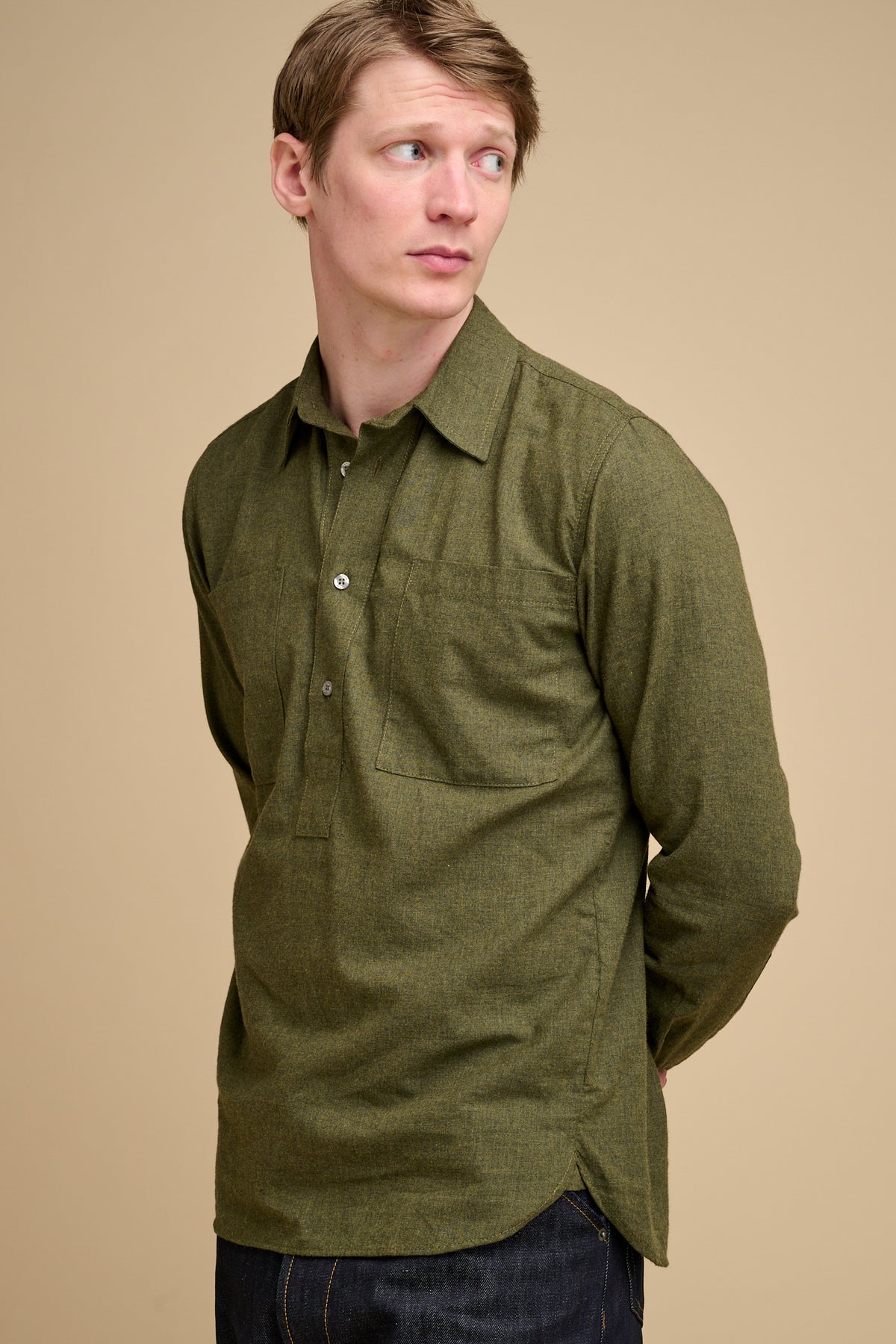 Man wearing an olive green brushed cotton shirt against a beige background.