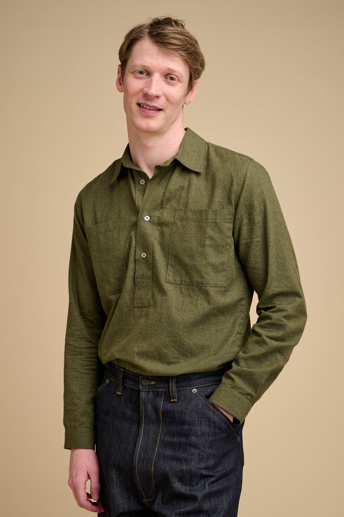 Man wearing an olive green brushed cotton shirt against a beige background.