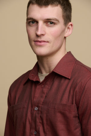 Portrait of brunet male wearing Oli shirt in brick red over crew neck t shirt in stone