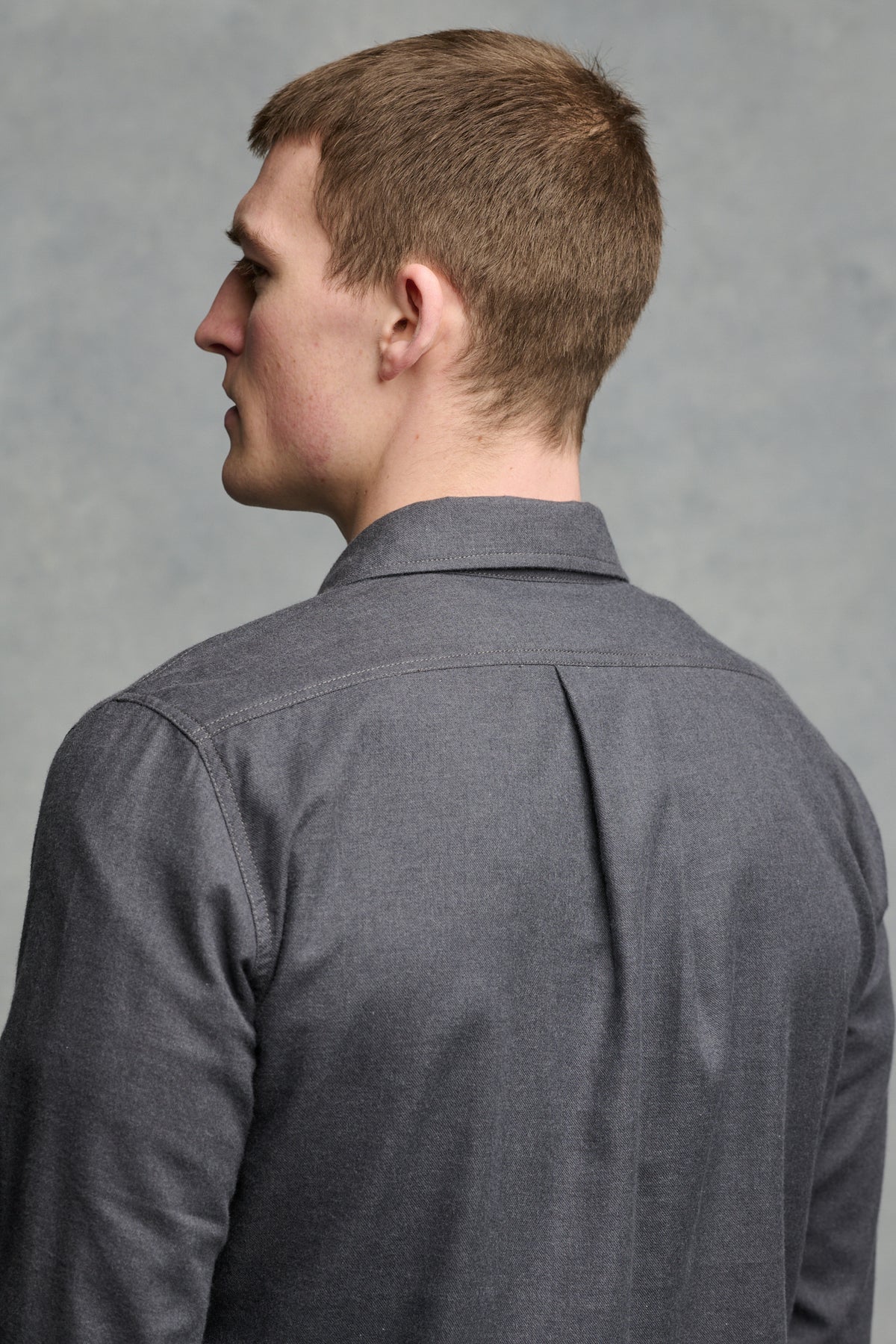 
            Close up of the back of shoulders of male wearing Oli shirt