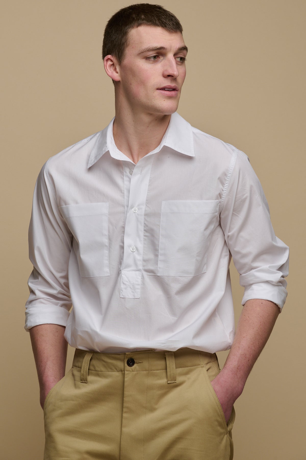 
            Thigh up image of the front of brunet male wearing Oli shirt in white tucked into field trousers in stone