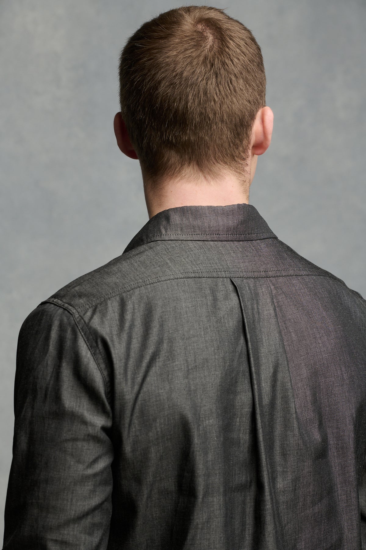 
            Close up of the back of males&#39; shoulders wearing Oli shirt showing pleat detail 