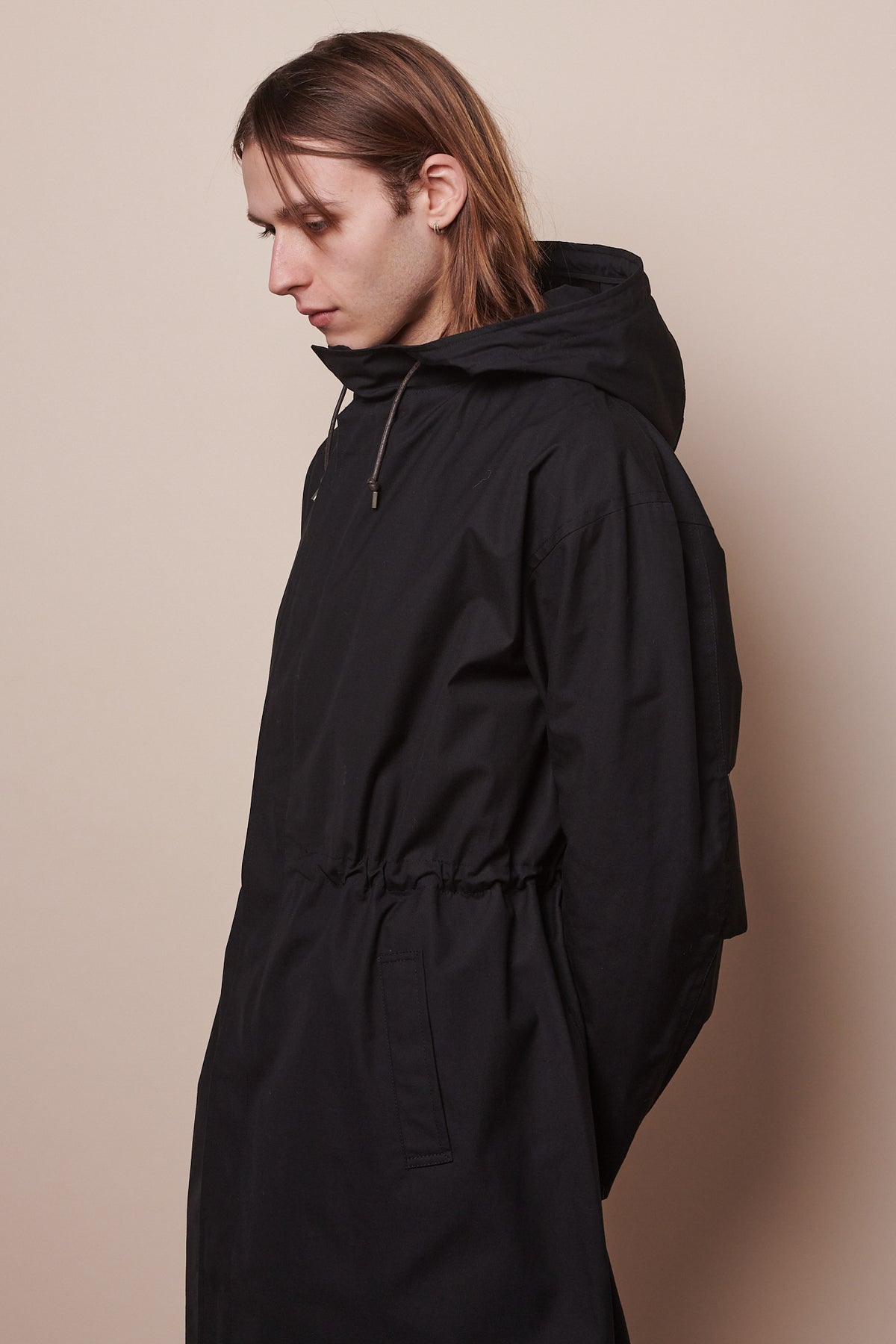 
            Thigh up image of male wearing zipped parka in black with waist synched in slightly with drawcord