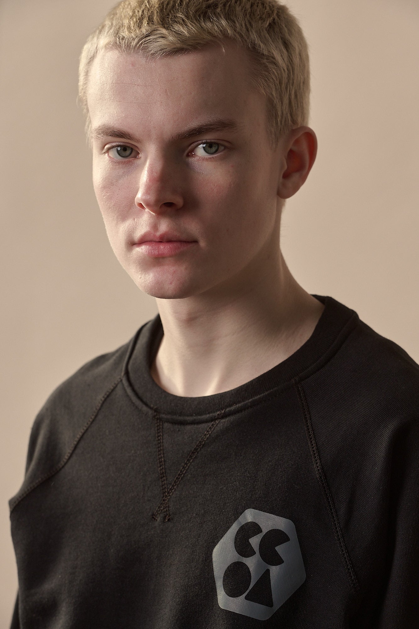 Portrait image of white male wearing men's raglan sweatshirt plastic free with CCOA logo
