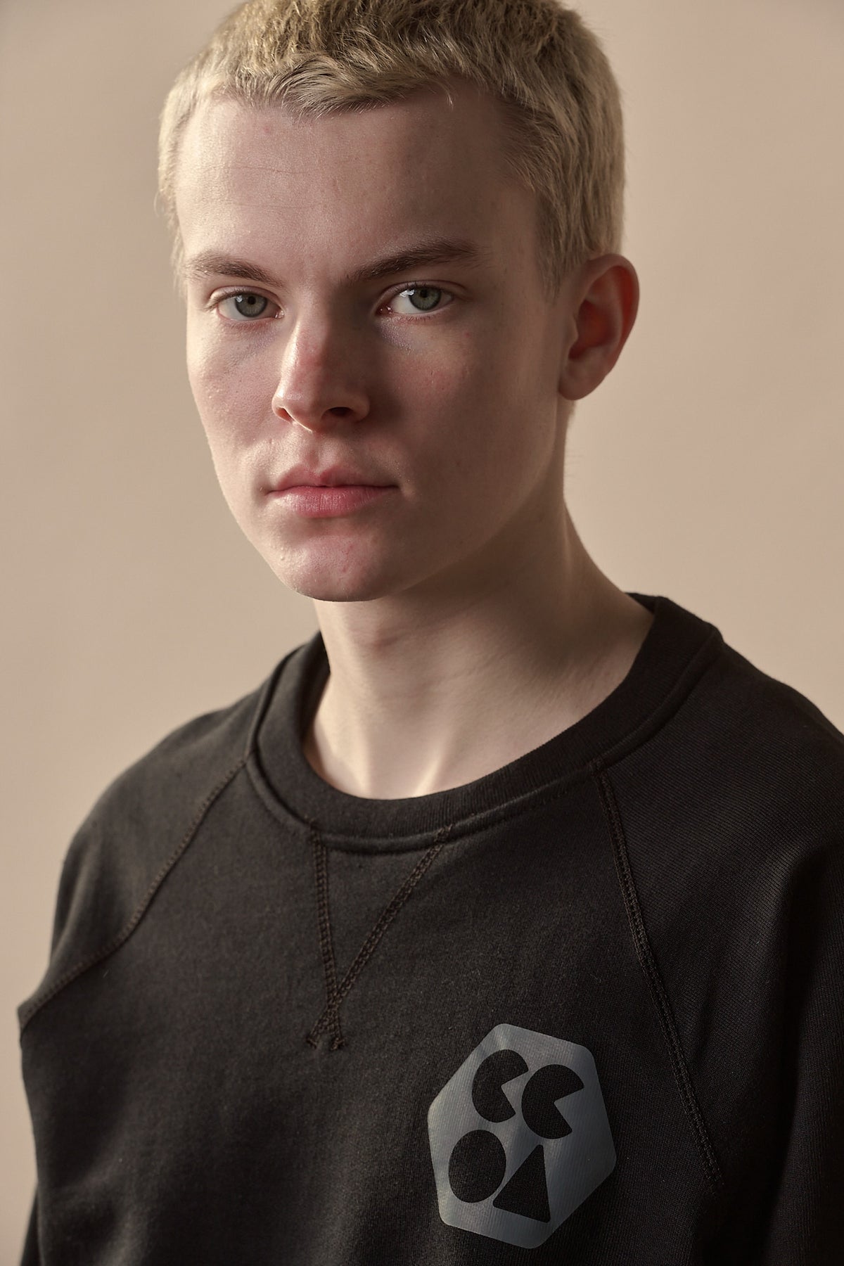 Portrait image of white male wearing men's raglan sweatshirt plastic free with CCOA logo