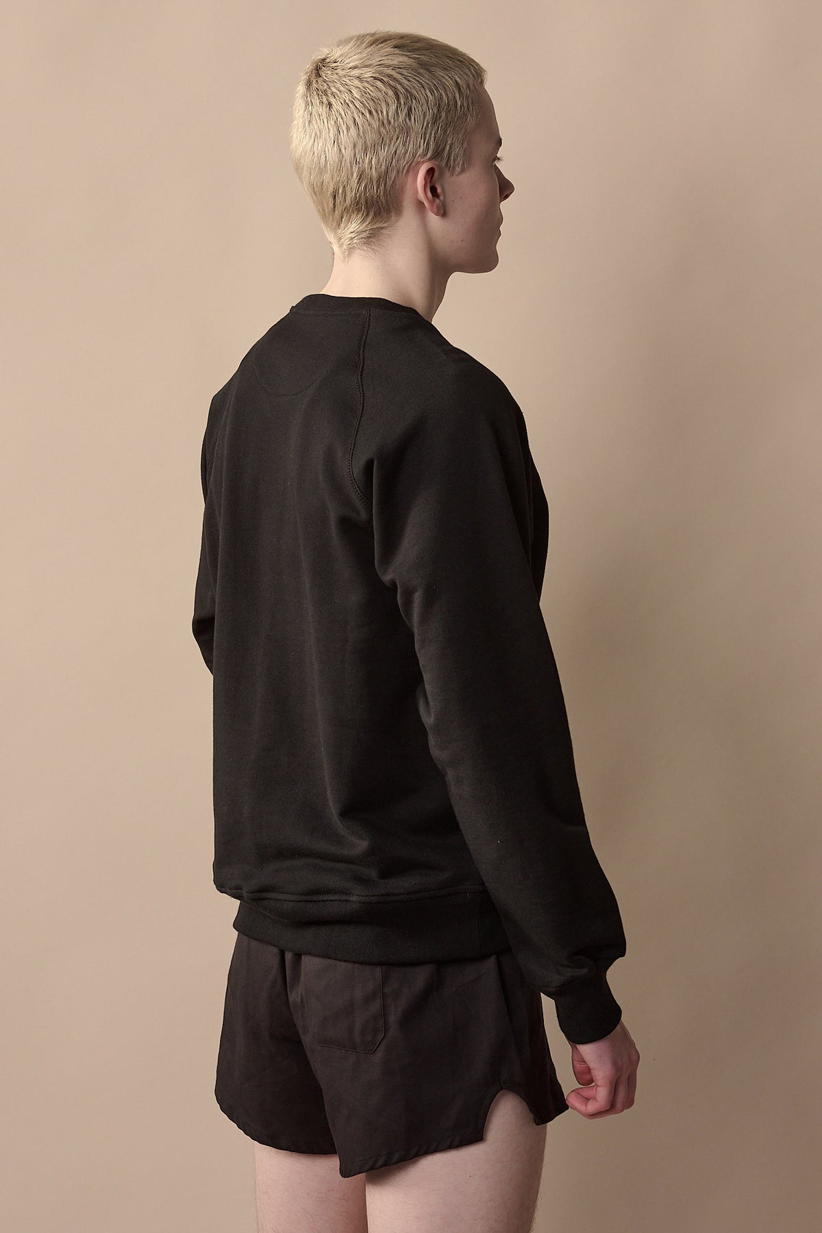 Image showing the back of white male wearing men's raglan sweatshirt plastic free with CCOA logo