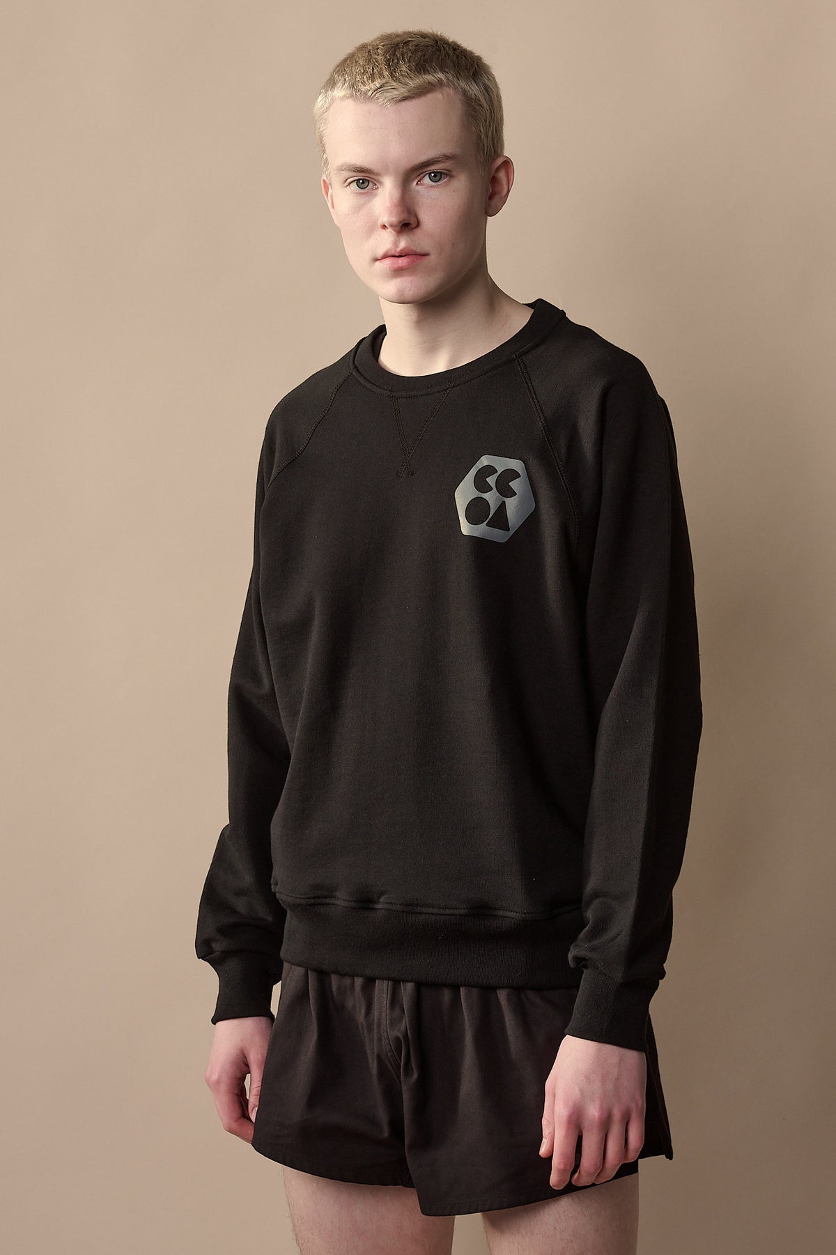 Thigh up image of white male wearing men's raglan sweatshirt plastic free with CCOA logo