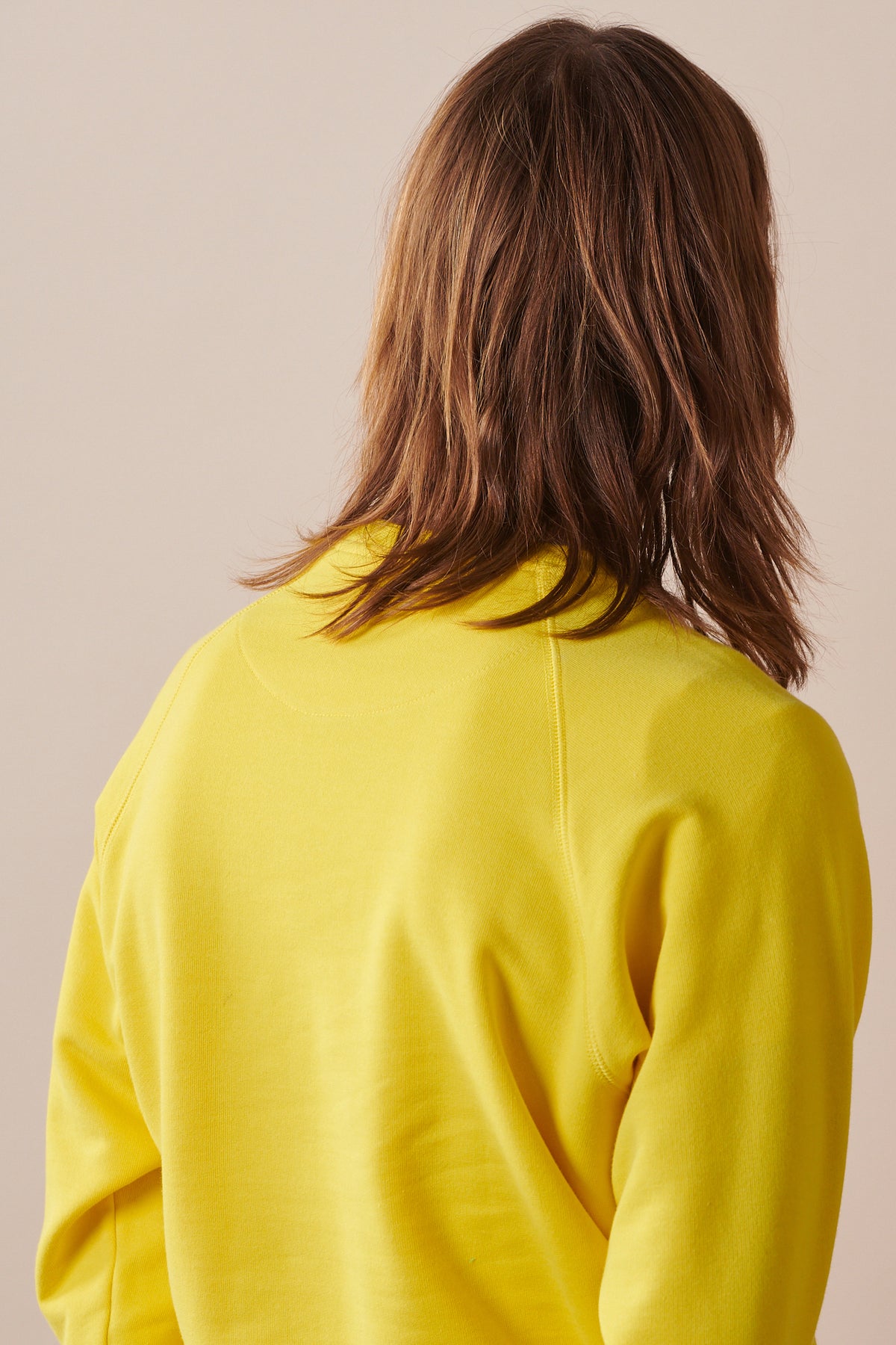 Back of male wearing raglan sweatshirt in canary yellow