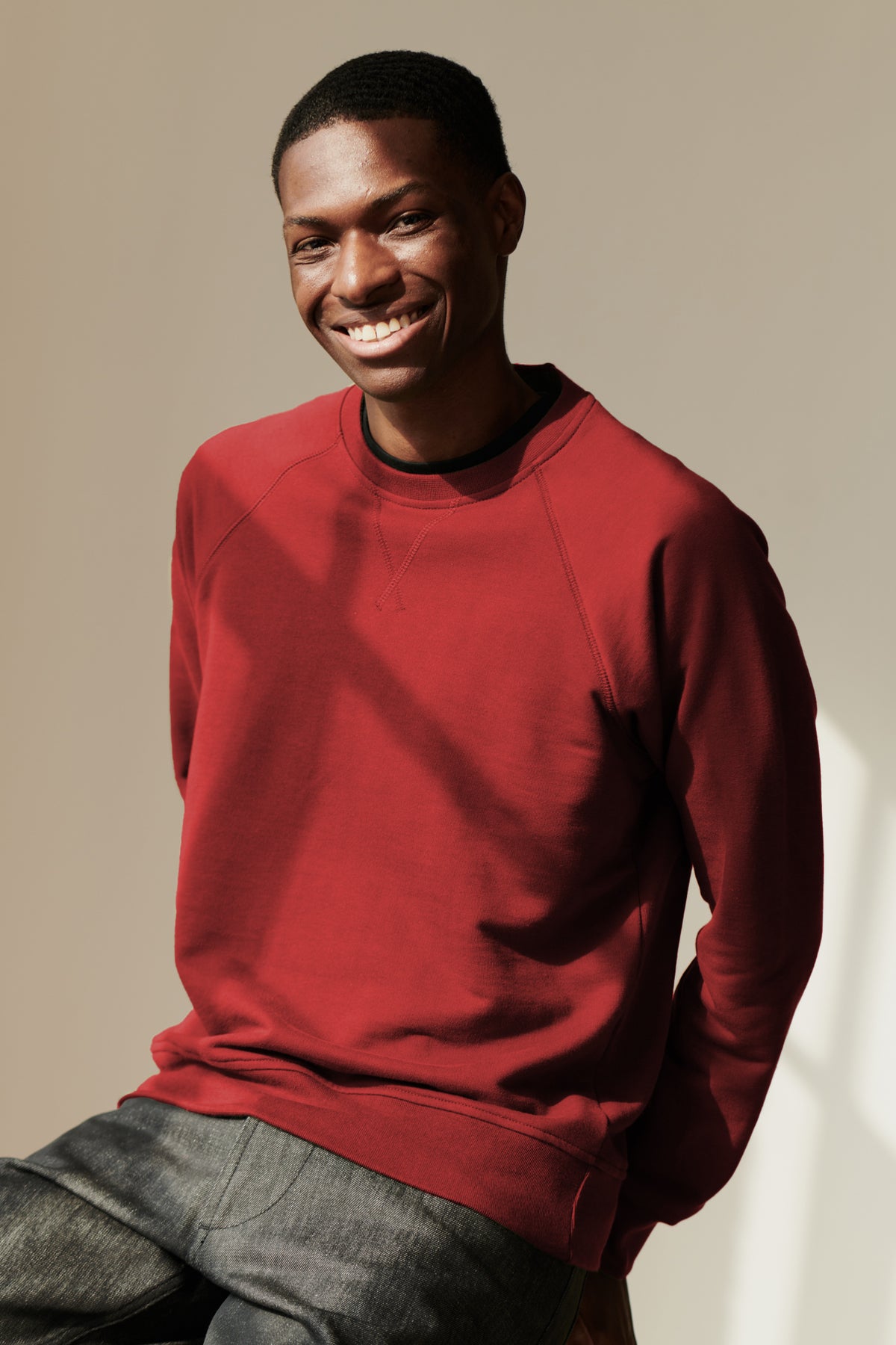 
            Smiley male wearing raglan sweatshirt in crimson