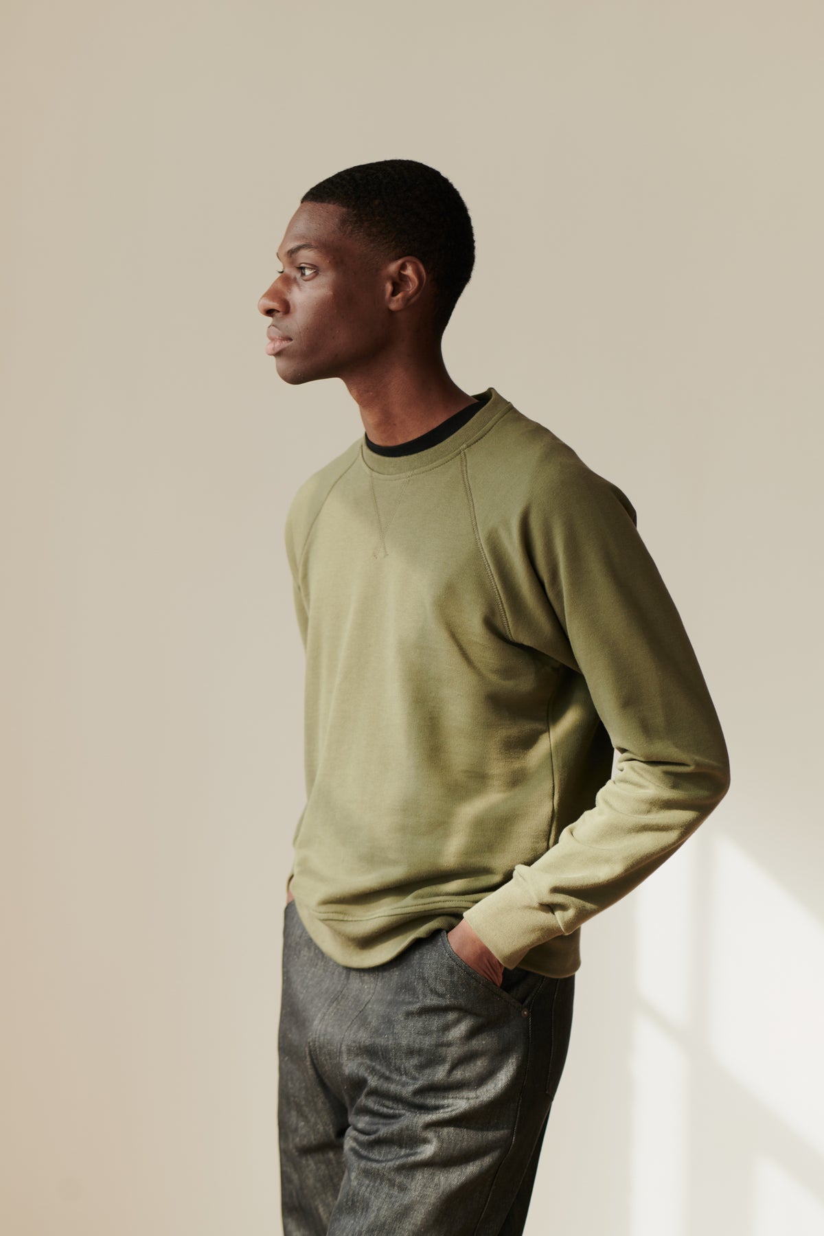 Front image of male wearing raglan sweatshirt in olive