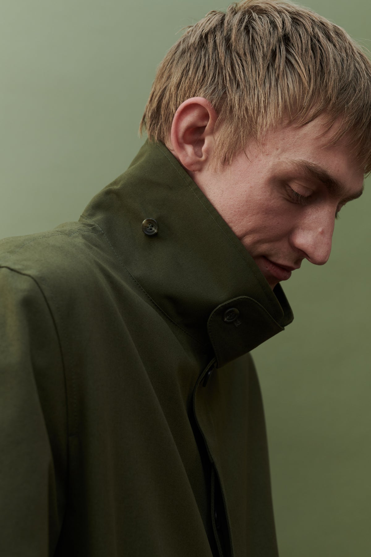 
            Image showing collar detail of men&#39;s raincoat in olive. Detachable collar strap