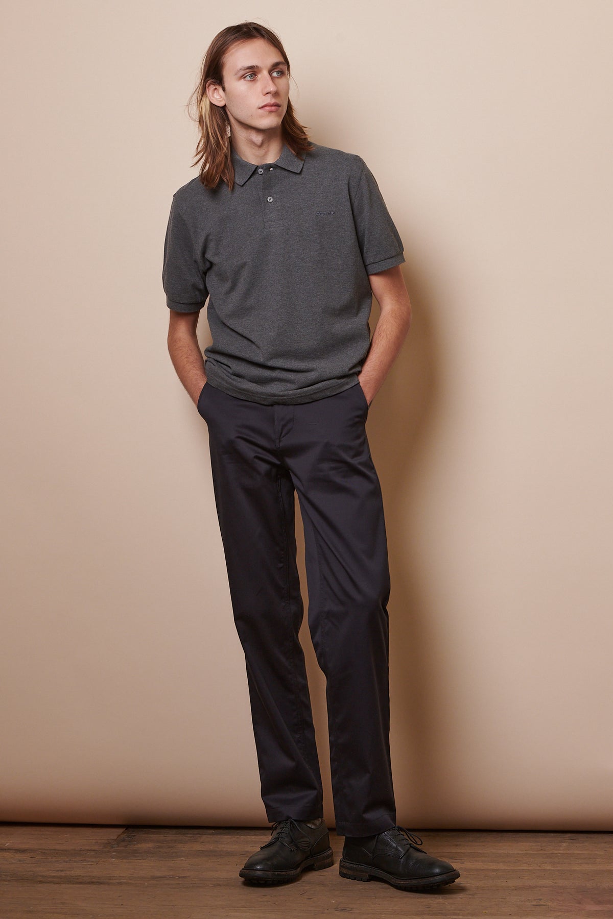 image showing male wearing short sleeve polo shirt in grey marl paired with navy chinos