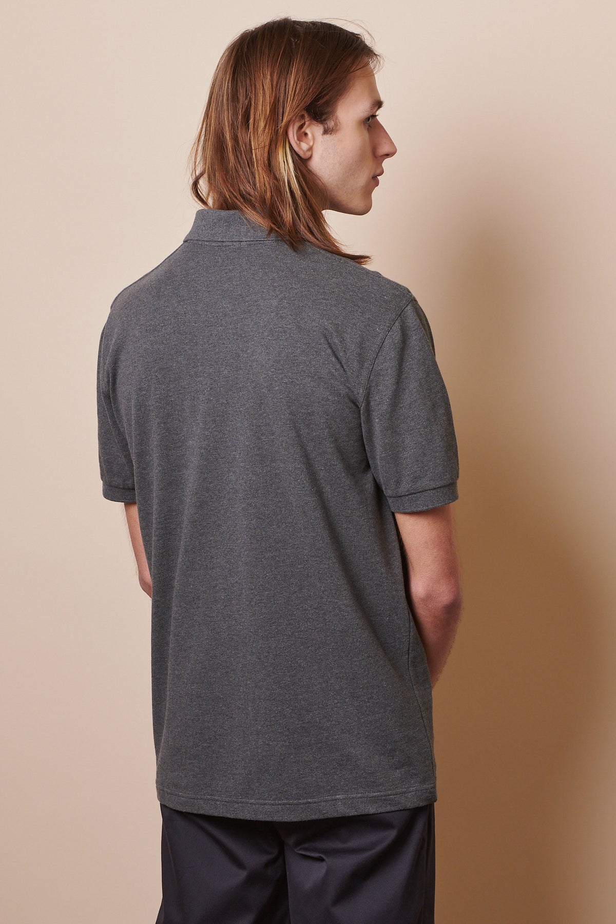 
            Back of male wearing short sleeve polo shirt in grey marl