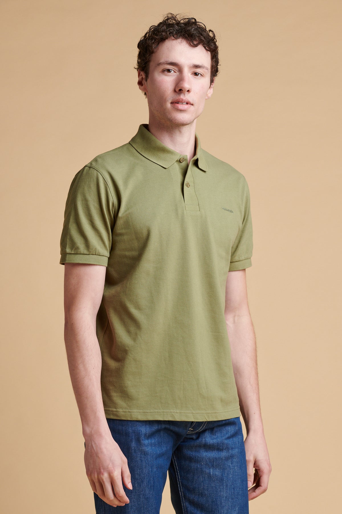 Thigh up of male wearing short sleeve polo shirt in light olive.