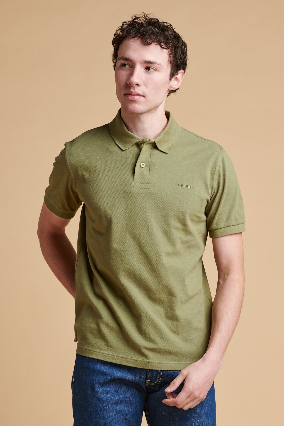Thigh up of male wearing short sleeve polo shirt in light olive.