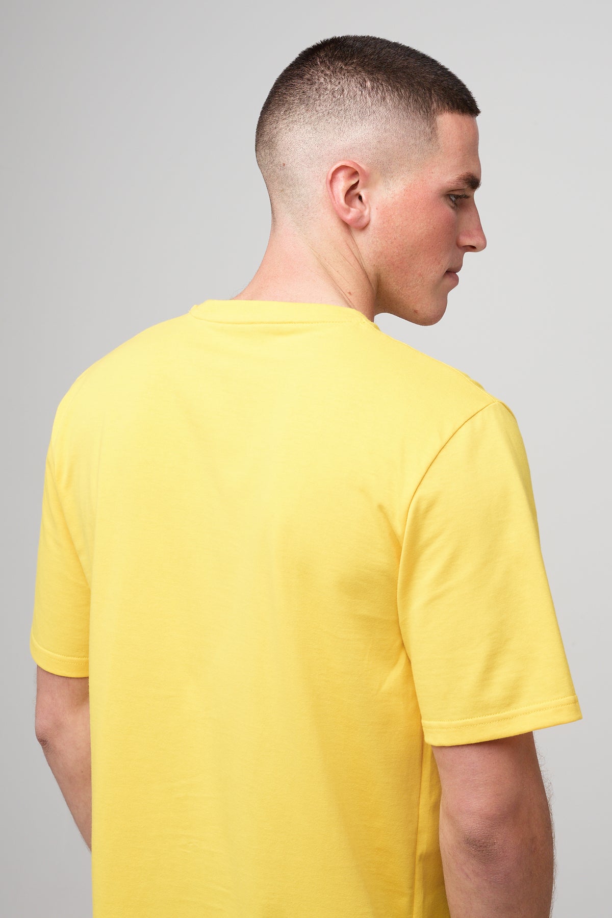 
            Brunet, white male in sunshine yellow short sleeve t-shirt, back