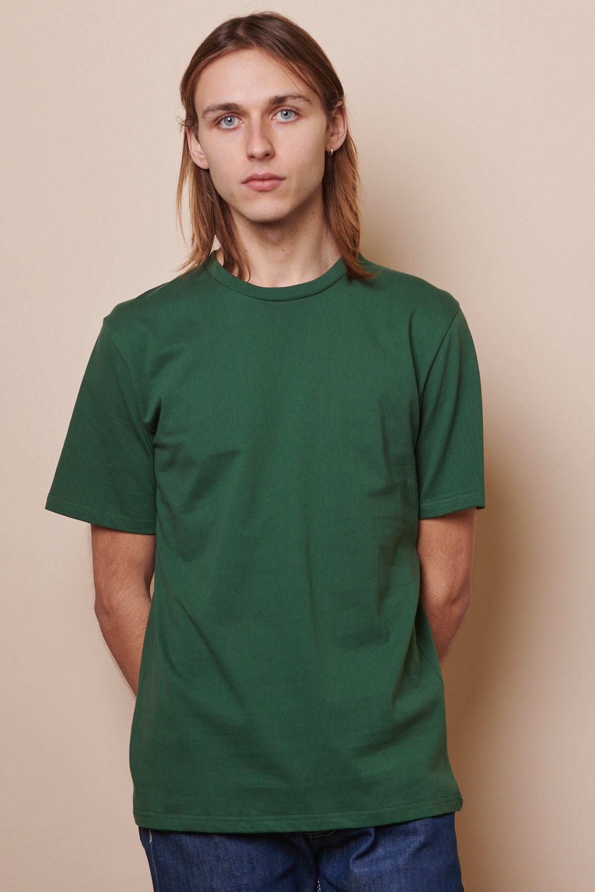 Front of male wearing crew neck t shirt in bottle green