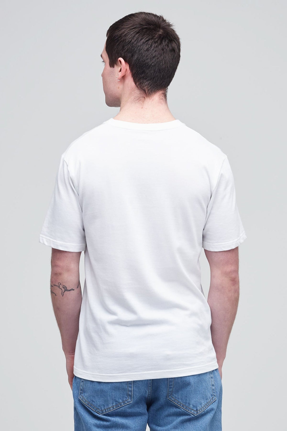 Back of male wearing short sleeve t shirt in white