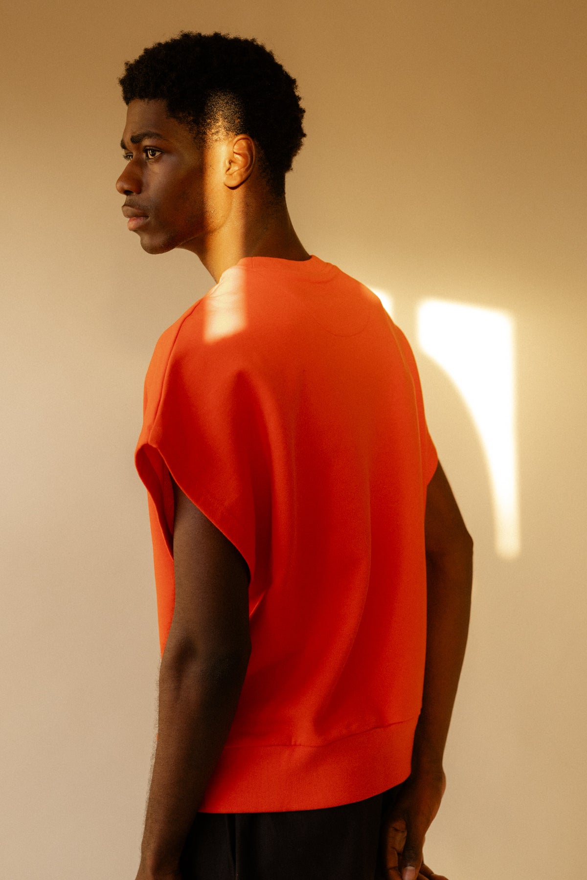 Image of the back of male wearing sleeveless sweatshirt plastic free flame red