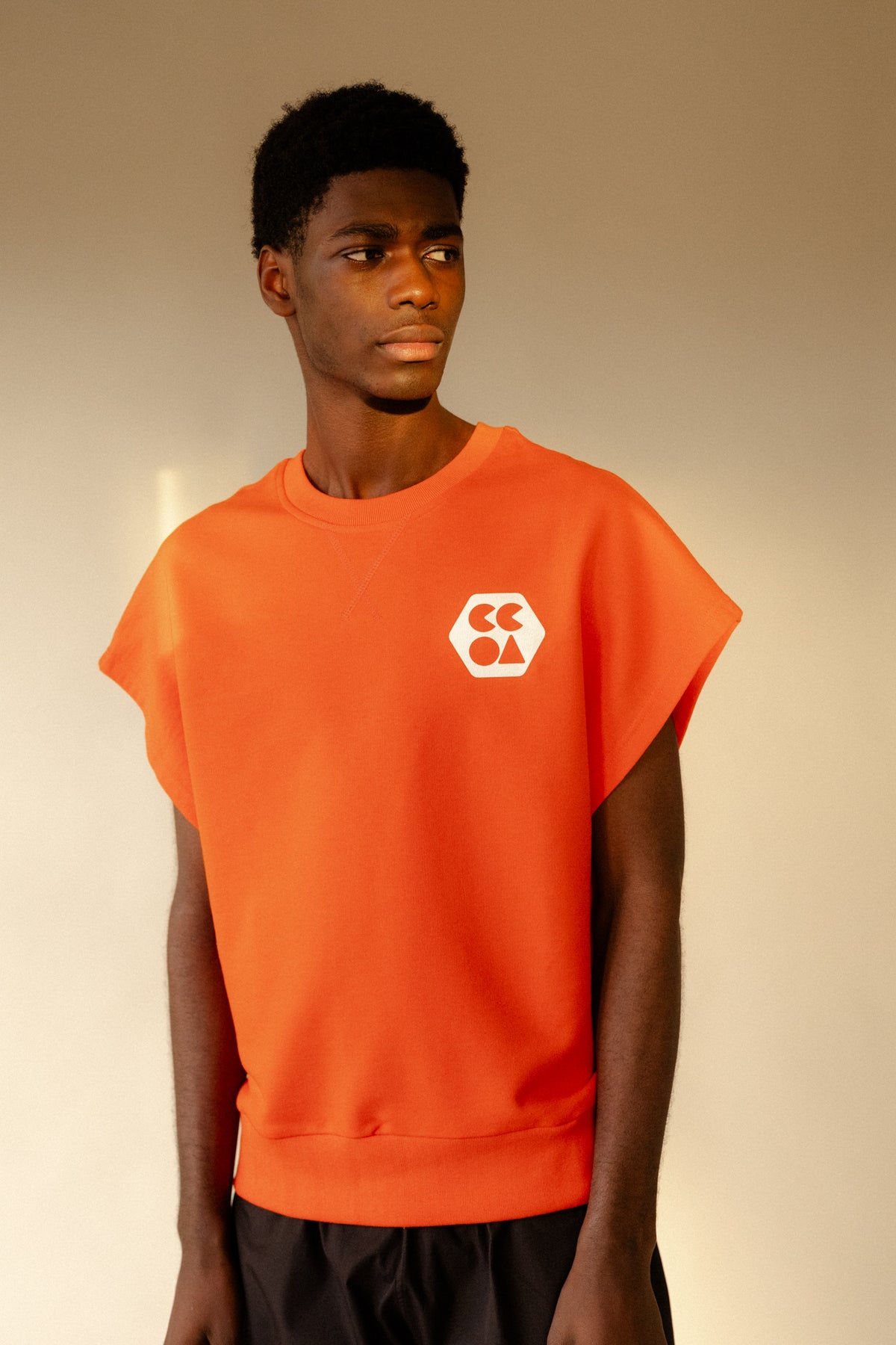 Thigh up image of male wearing sleeveless sweatshirt plastic free flame red