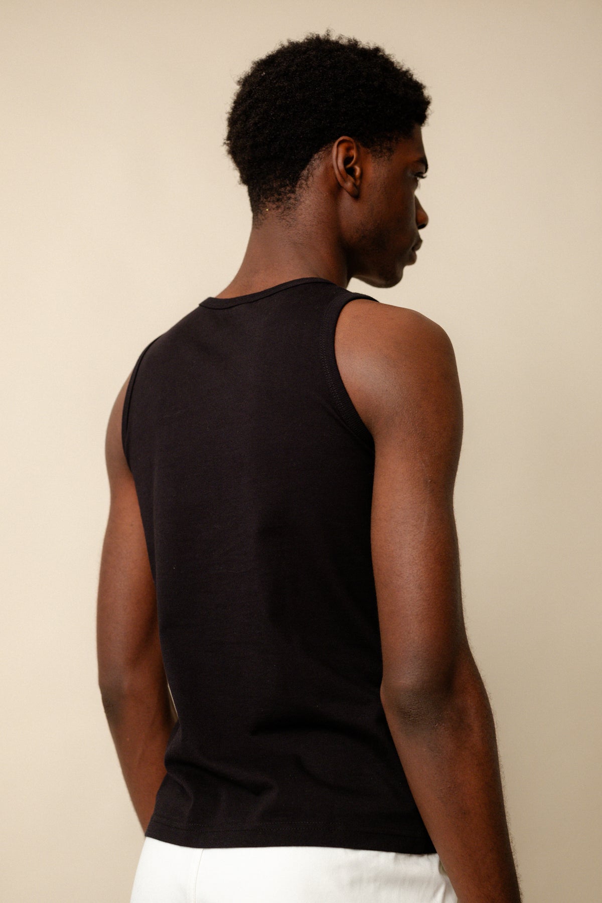 
            Back of black male wearing sleeveless t shirt