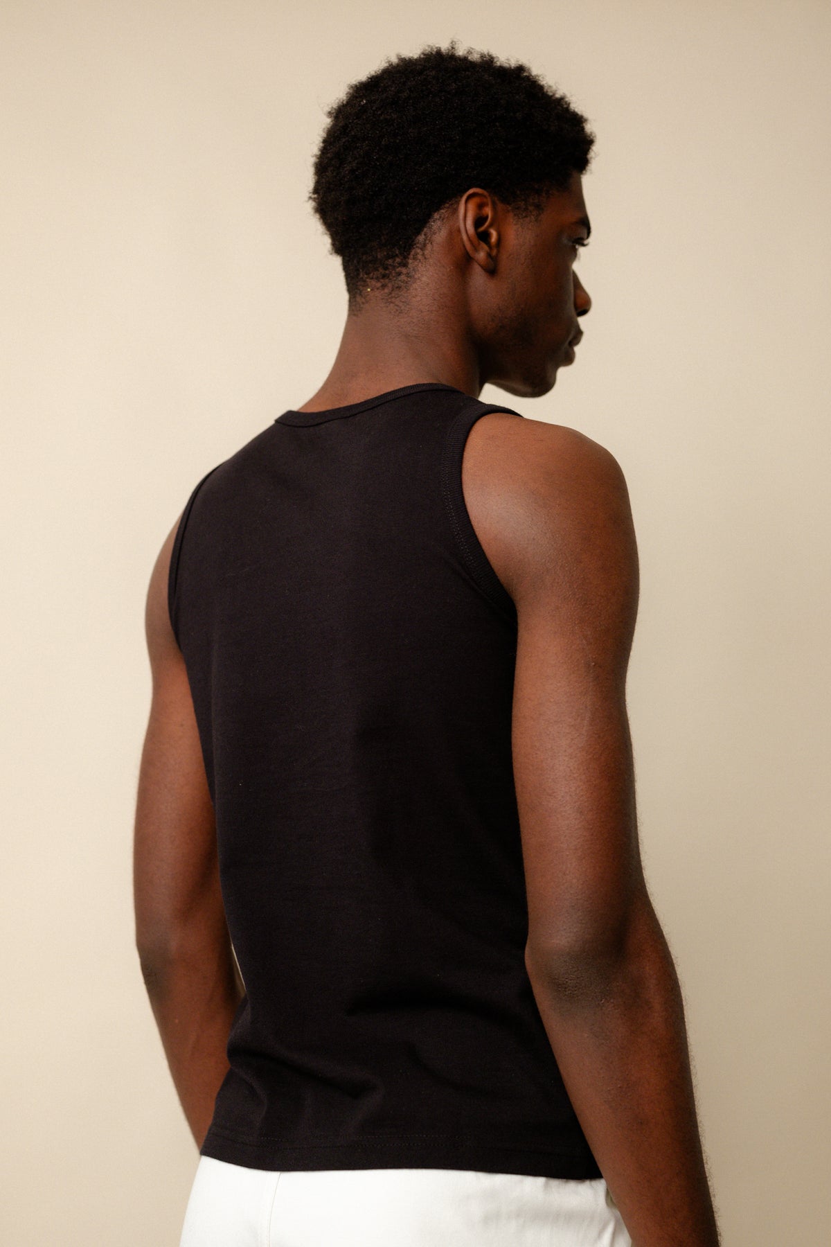 Back of black male wearing sleeveless t shirt