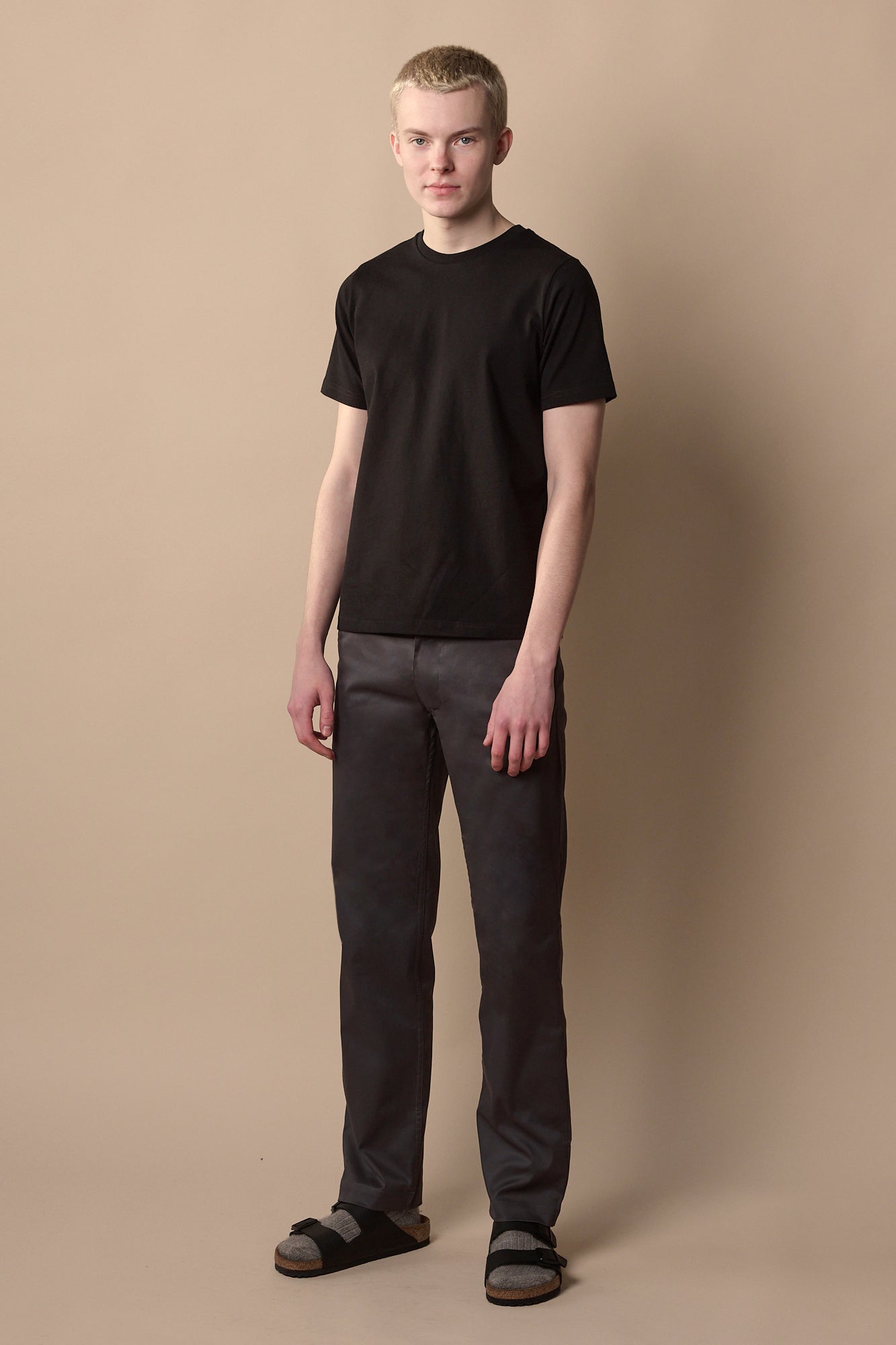 Full body image of men's slim stretch chino in slate grey paired with short sleeve black crew neck t shirt