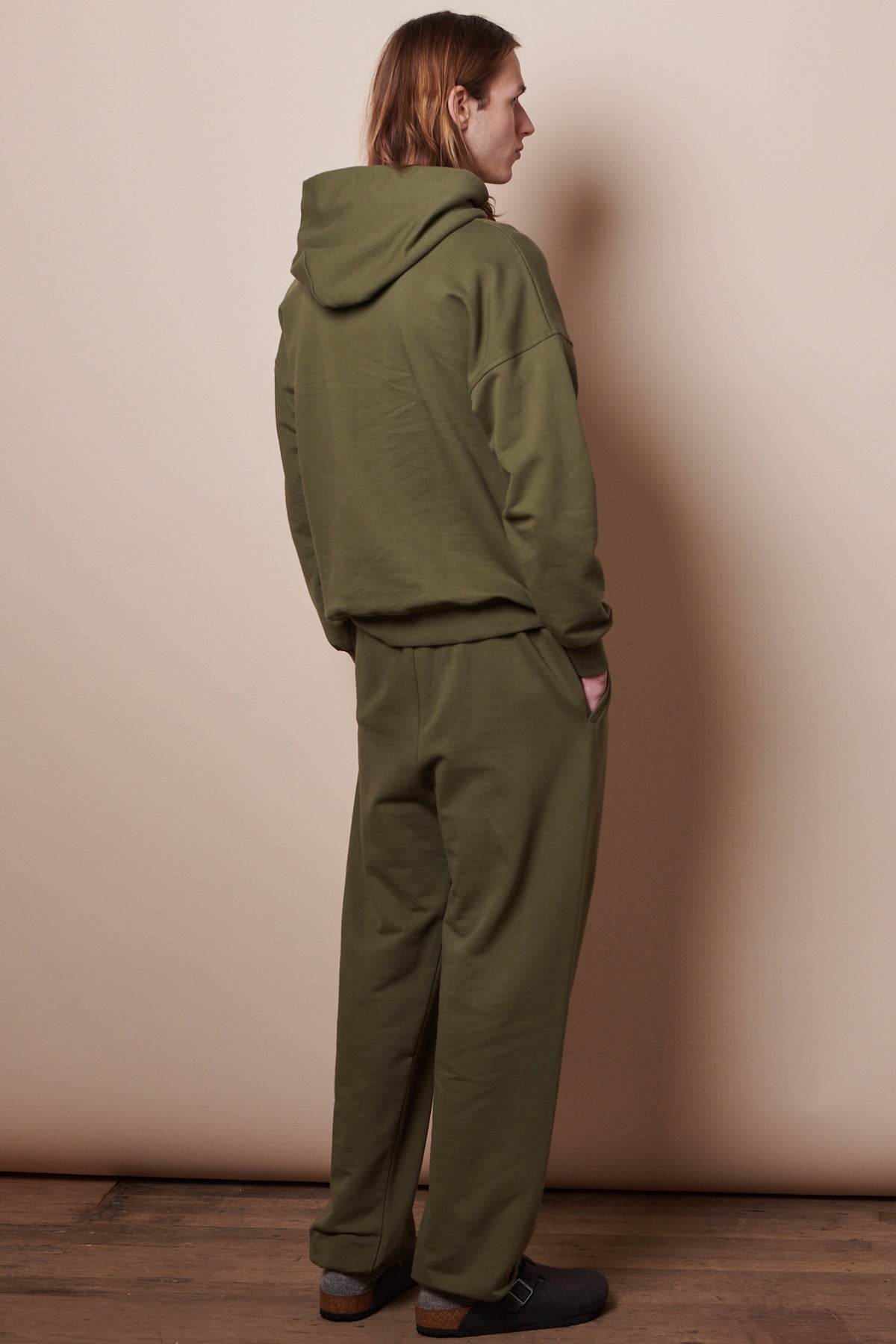 back of male wearing matching olive hoodie and jogger set