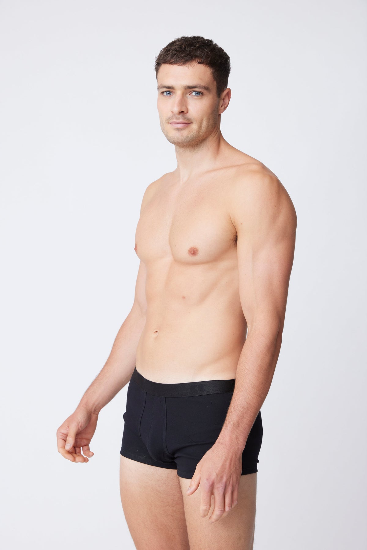 white male wearing black trunks